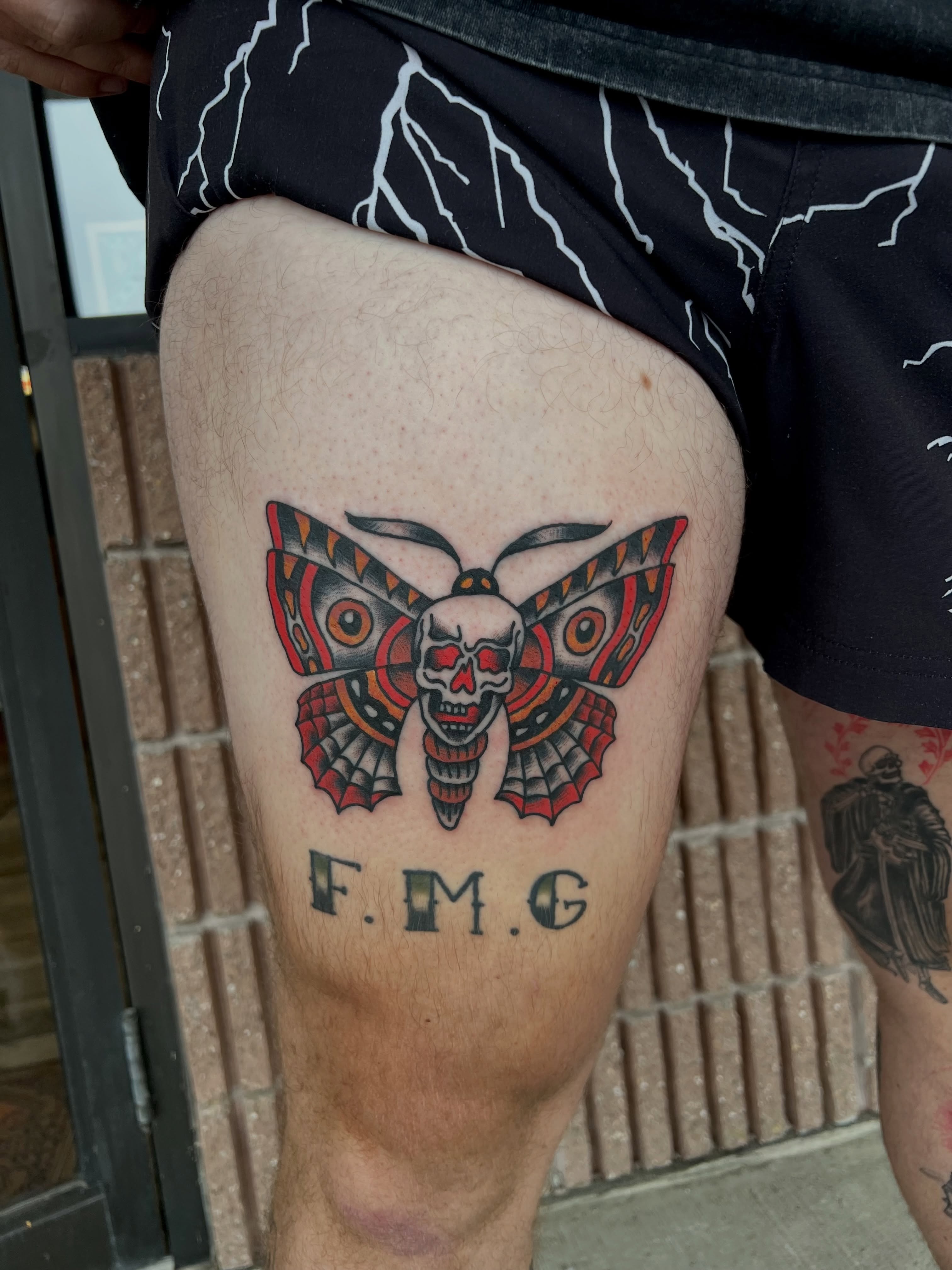 Skull moth American traditional tattoo on the thigh by Christopher Durao