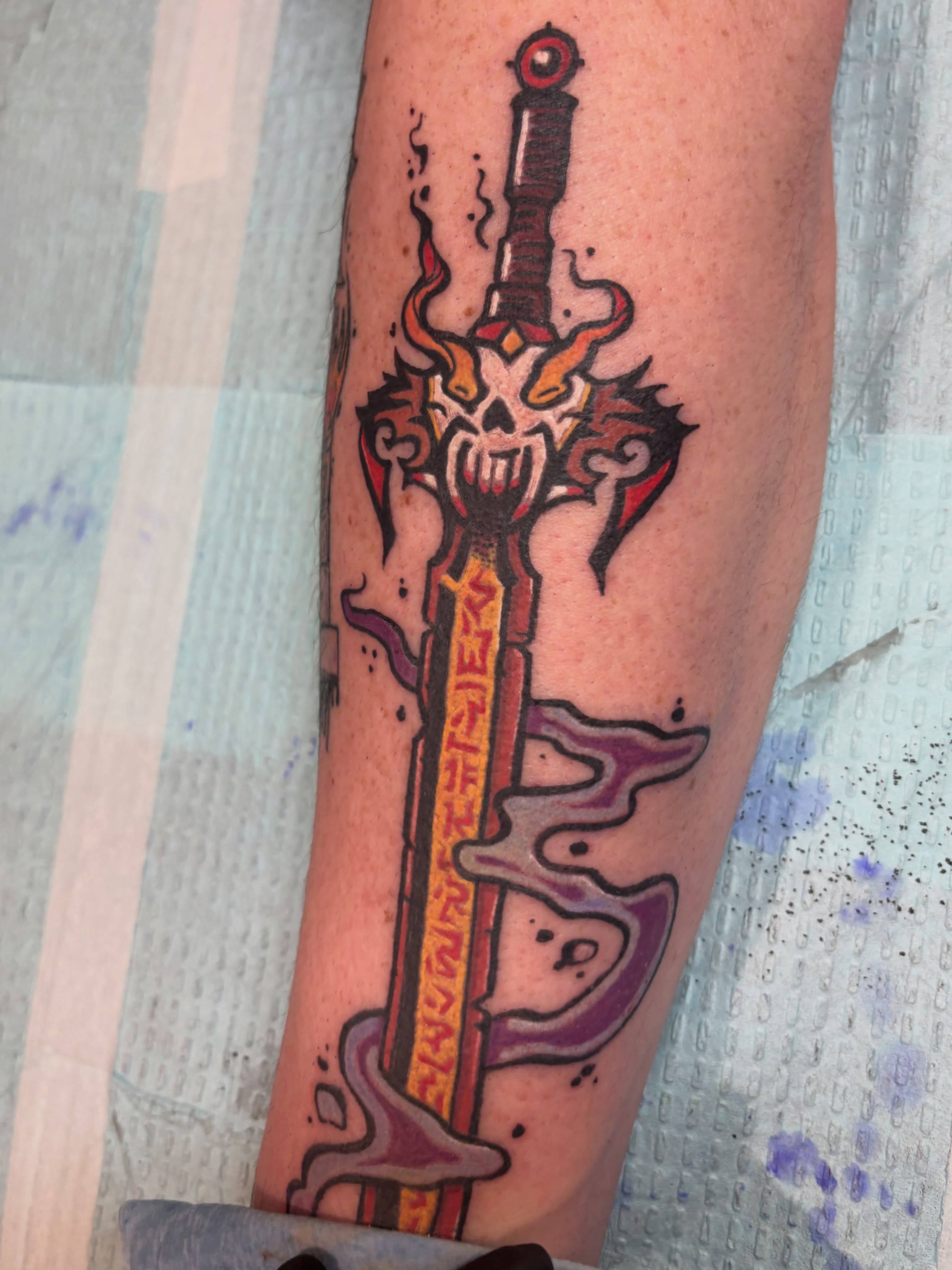 Sword with skull American traditional tattoo on the forearm by Zoe Brookes