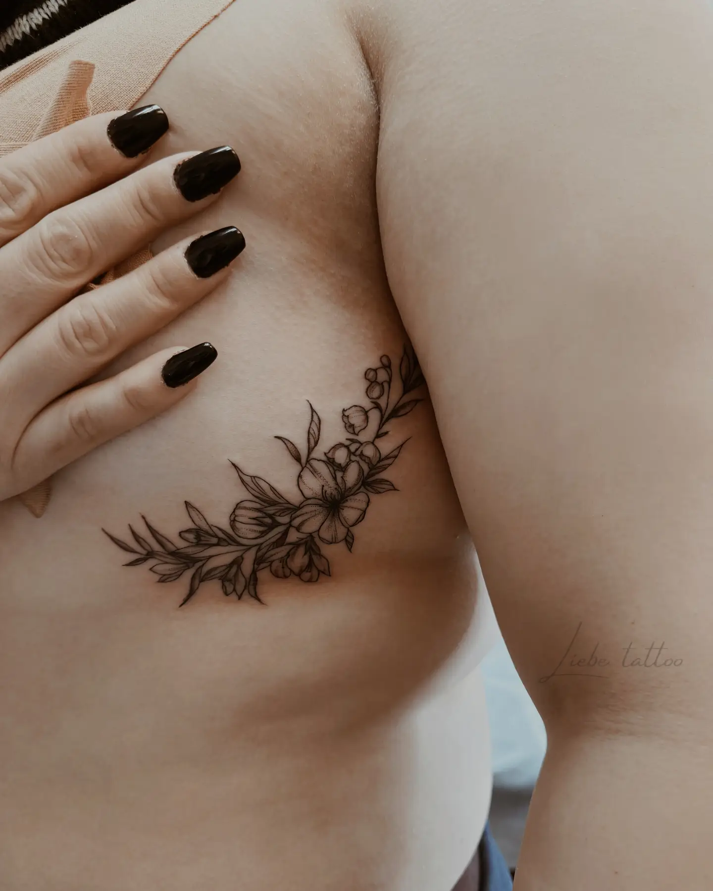 Floral arrangement black and grey tattoo on the chest by Floral Fineline Tattoo