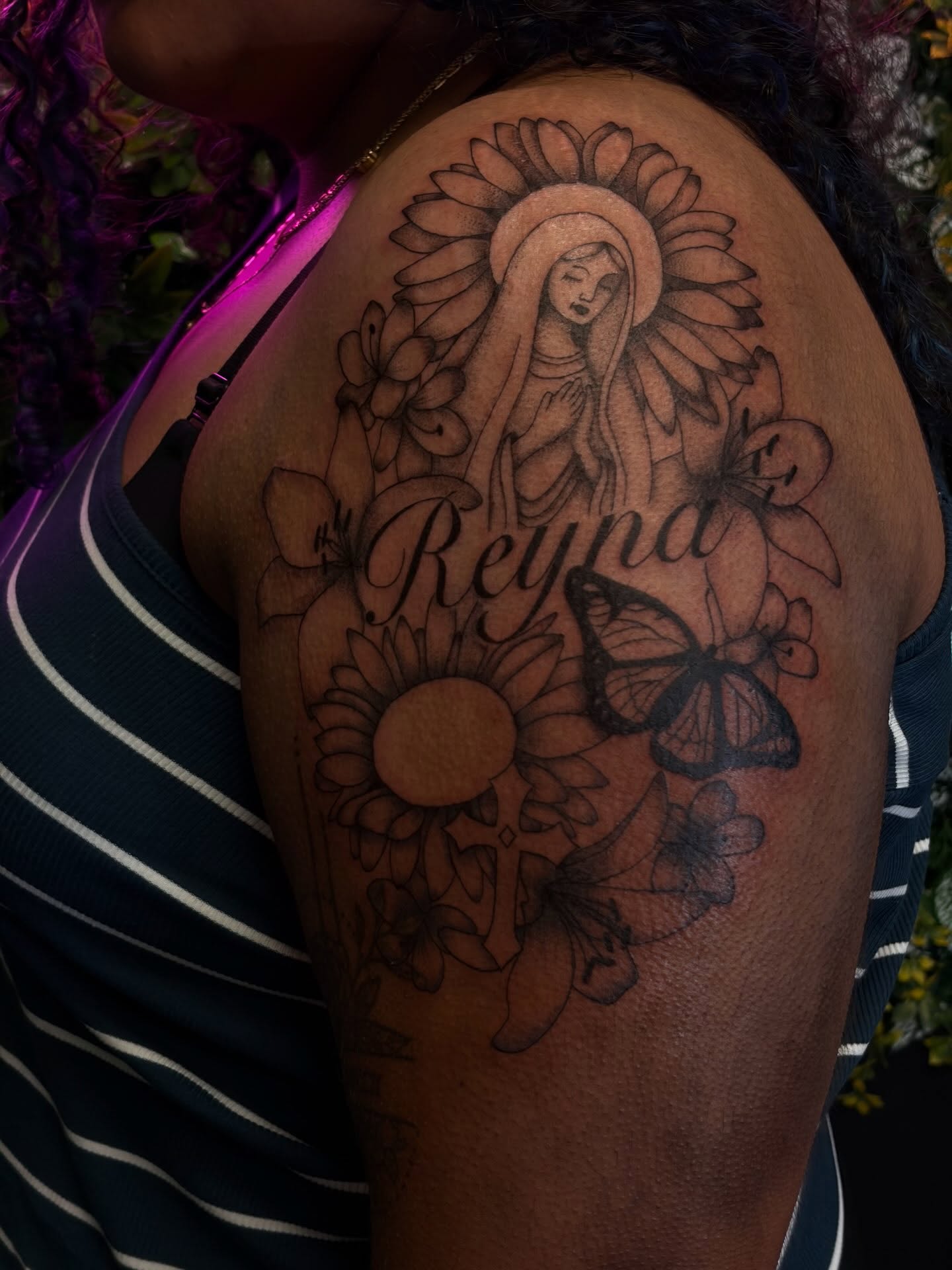 Religious figure with sunflowers black and grey tattoo on the shoulder by Melissa