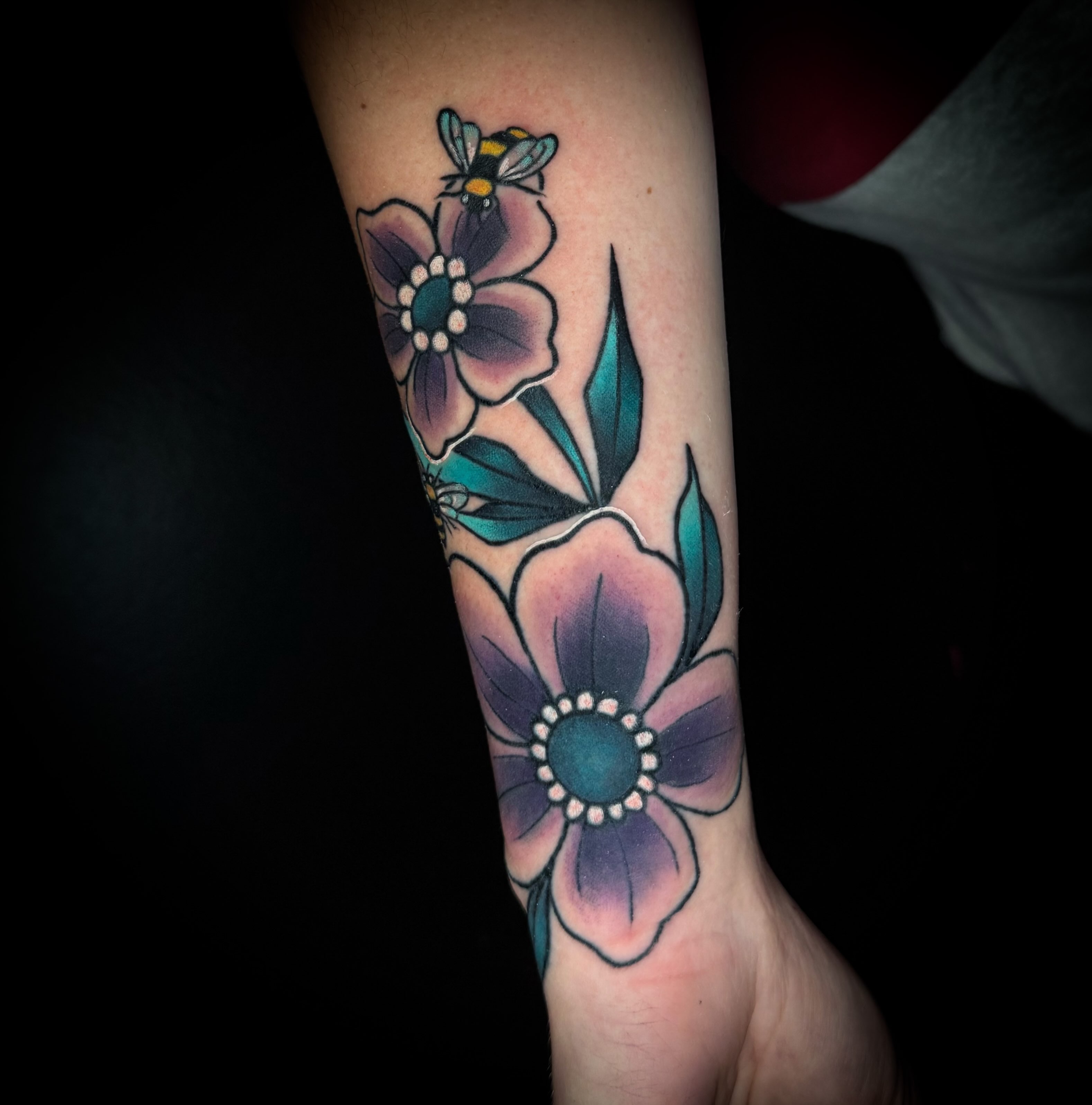 Flowers and bee American traditional tattoo on the forearm by Savannah Duff