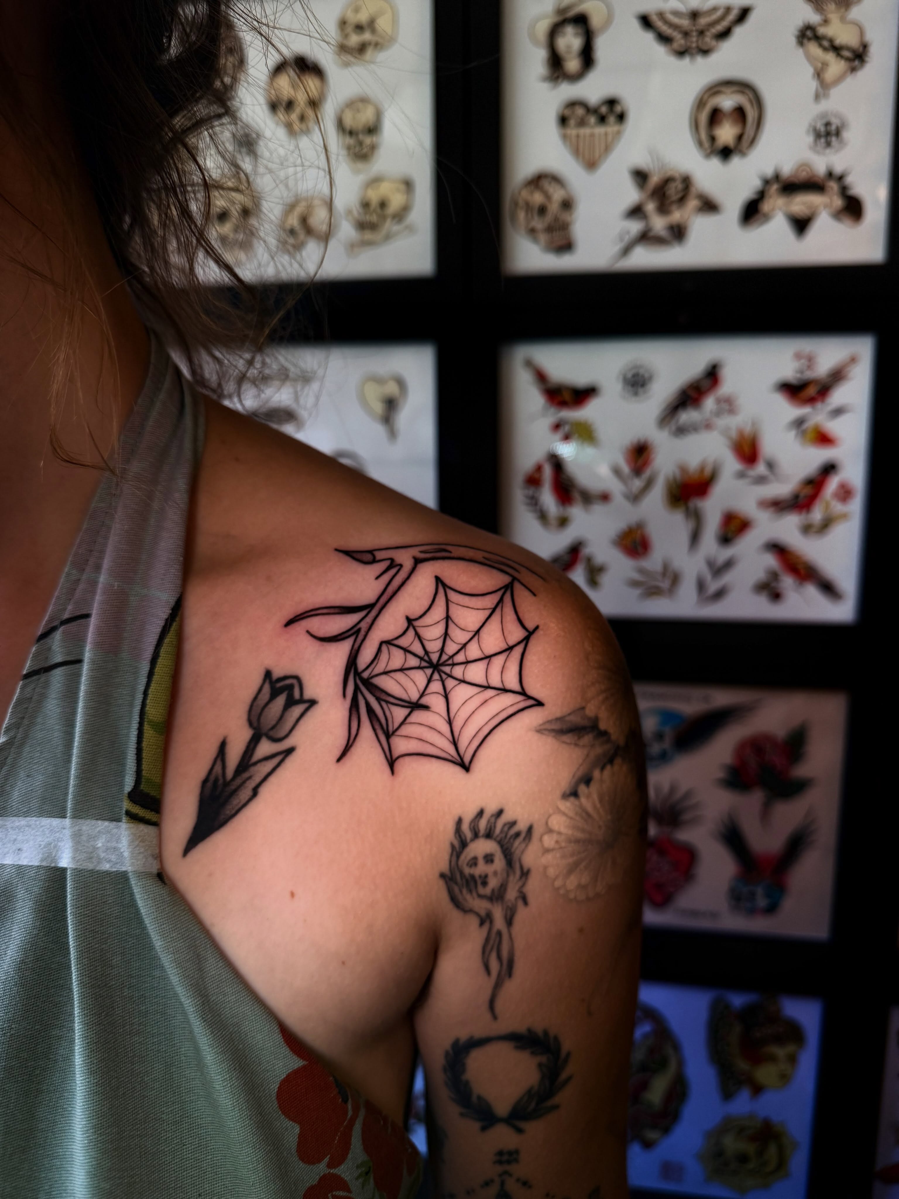 Spider web and tulip black and grey tattoo on the shoulder by Erin Shea
