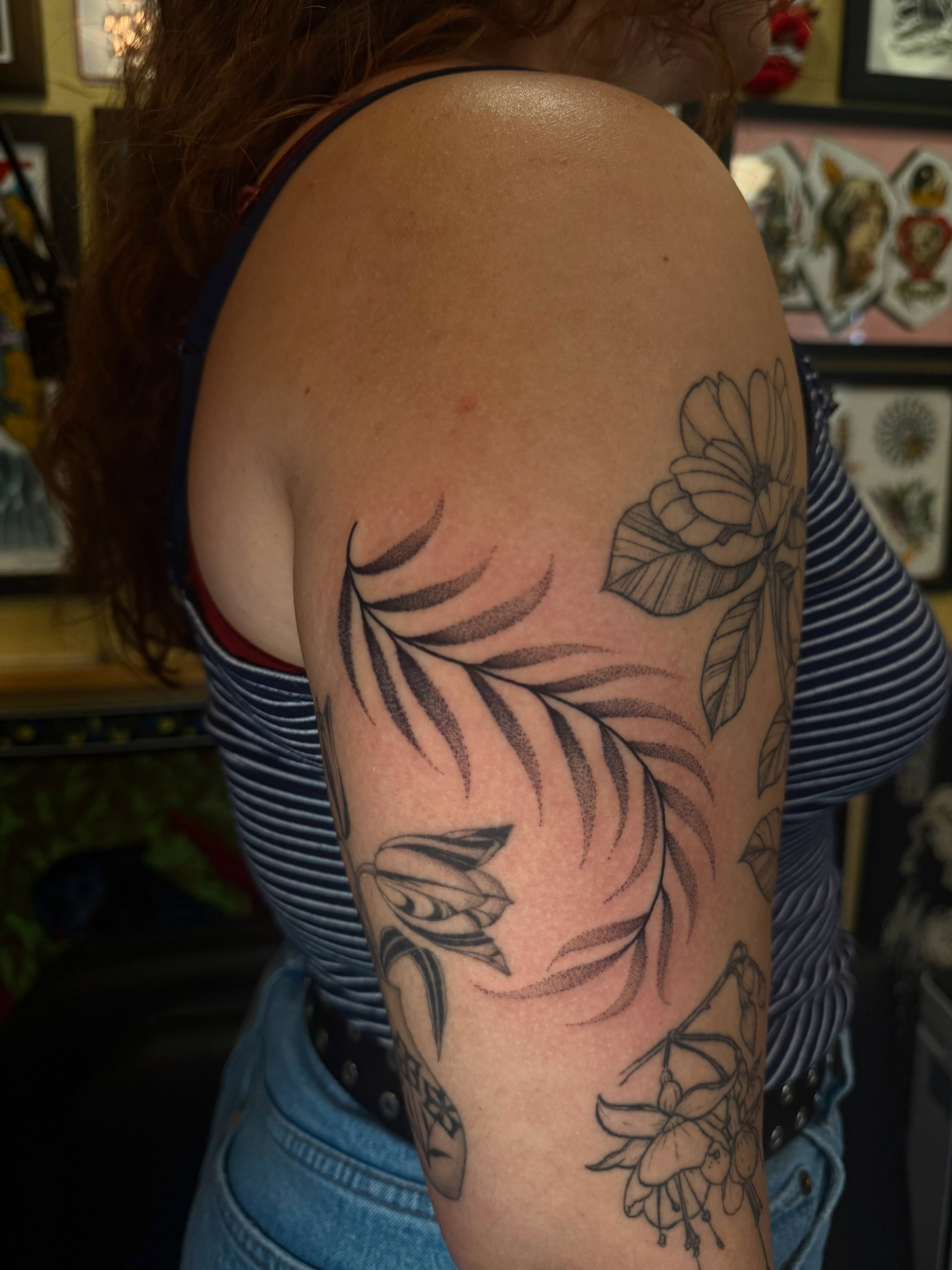 Floral arrangement black and grey tattoo on the upper arm by Erin Shea