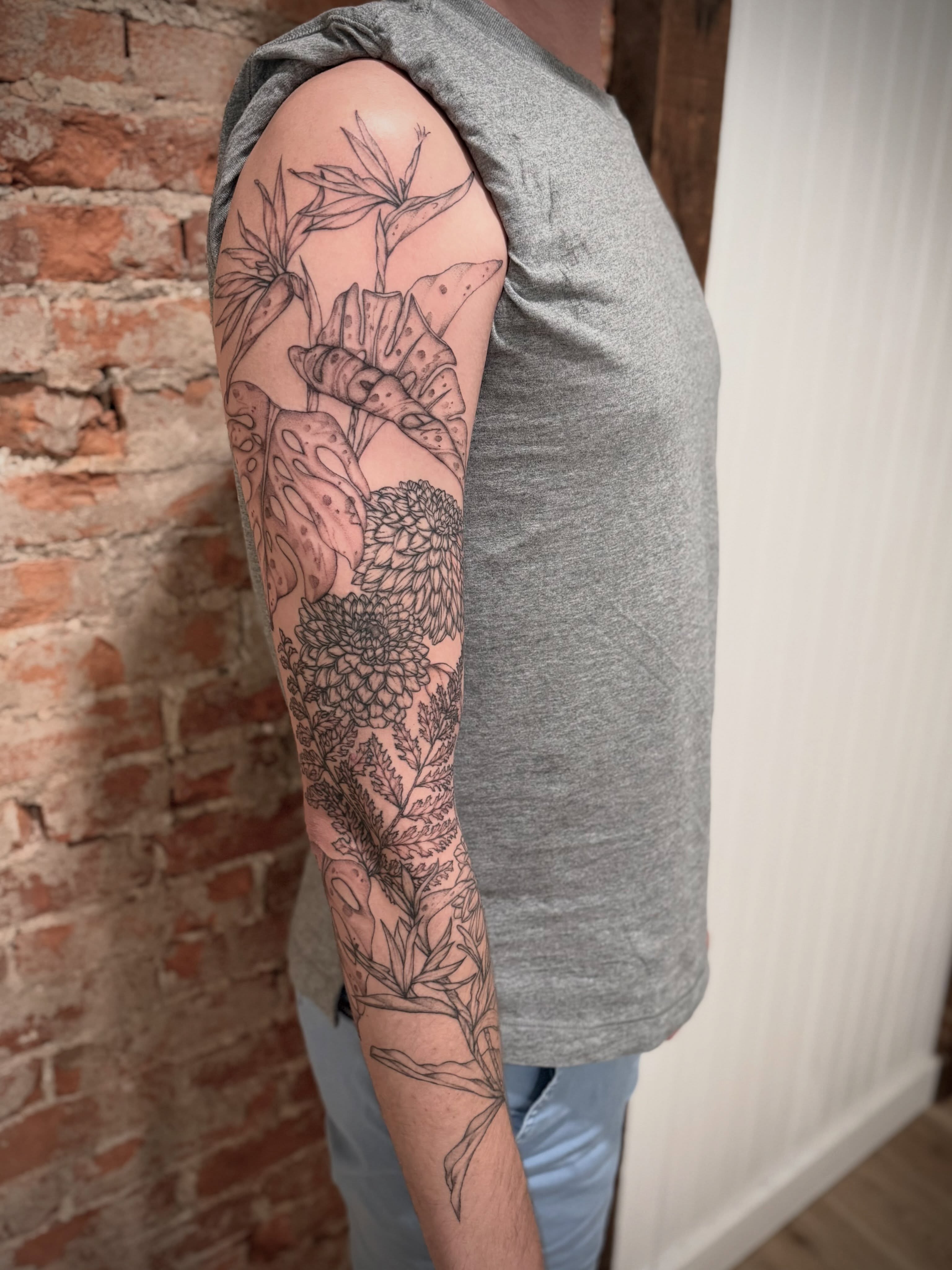 Floral arrangement black and grey tattoo on the upper arm by Daniel Anthony, Philadelphia, Pennsylvania