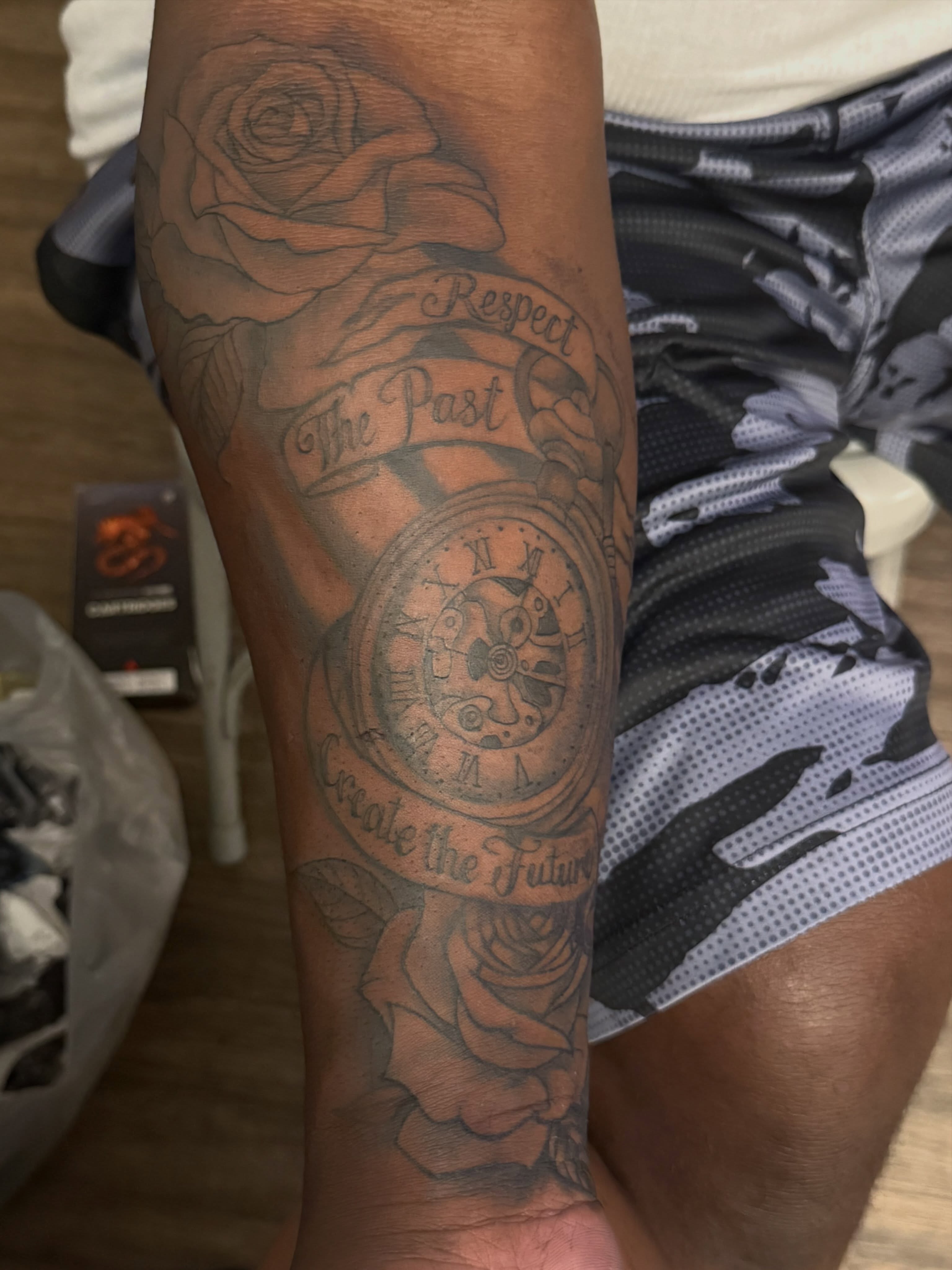 Clock and roses black and grey tattoo on the forearm by Aja Marie