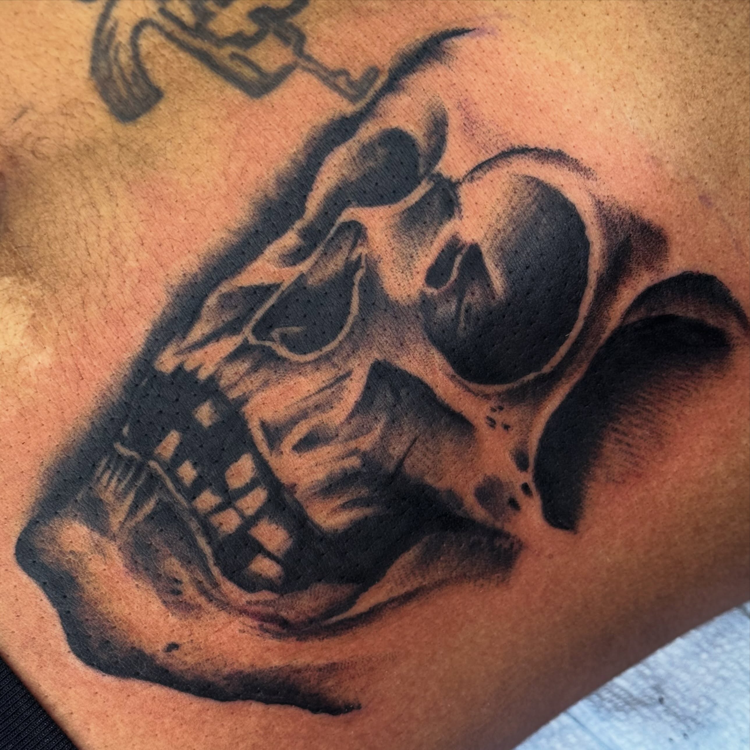 Skull black and grey tattoo on the chest by Jack Hatchet Tattoos
