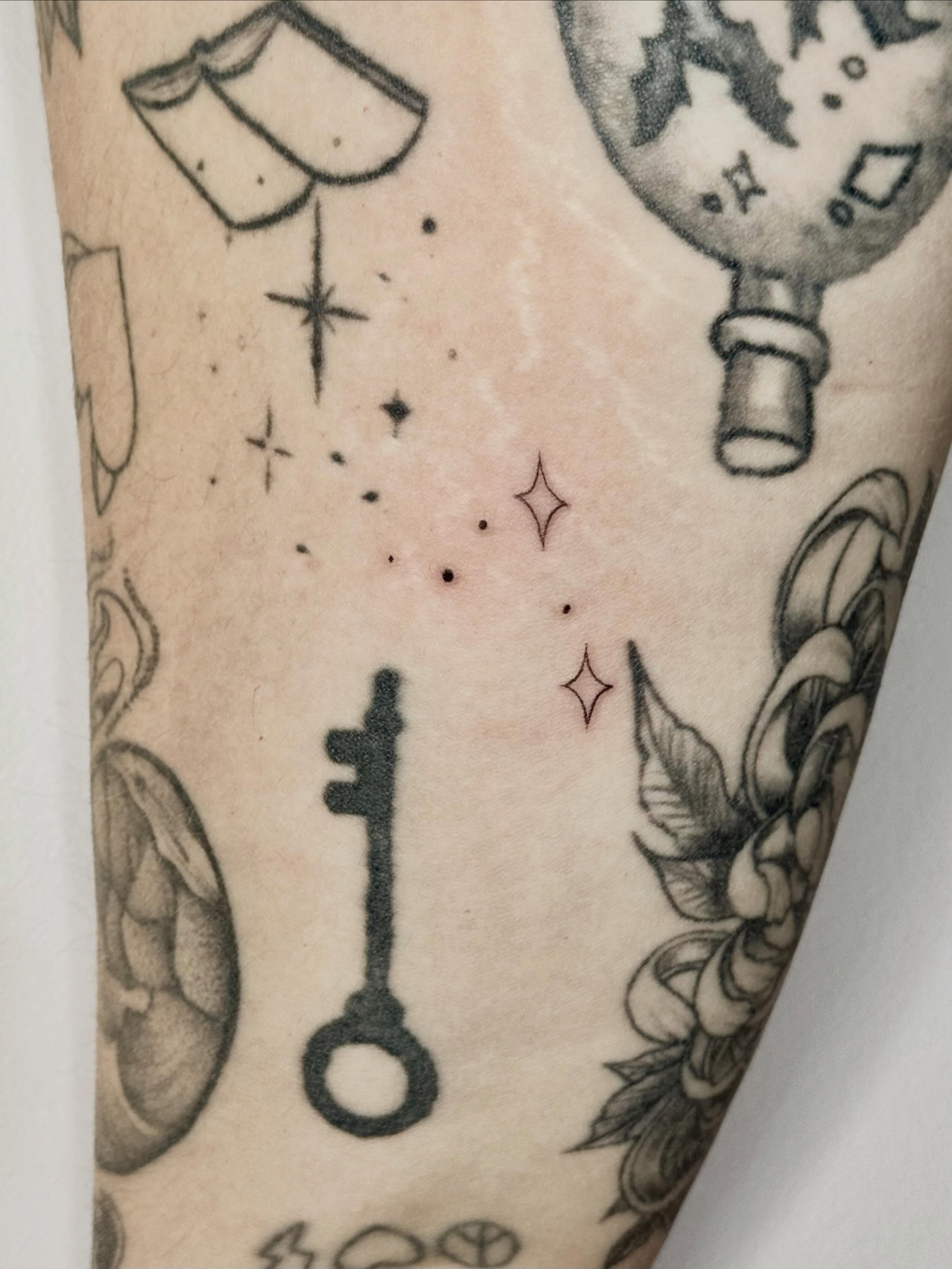 Key black and grey tattoo on the forearm by Sierra Seton