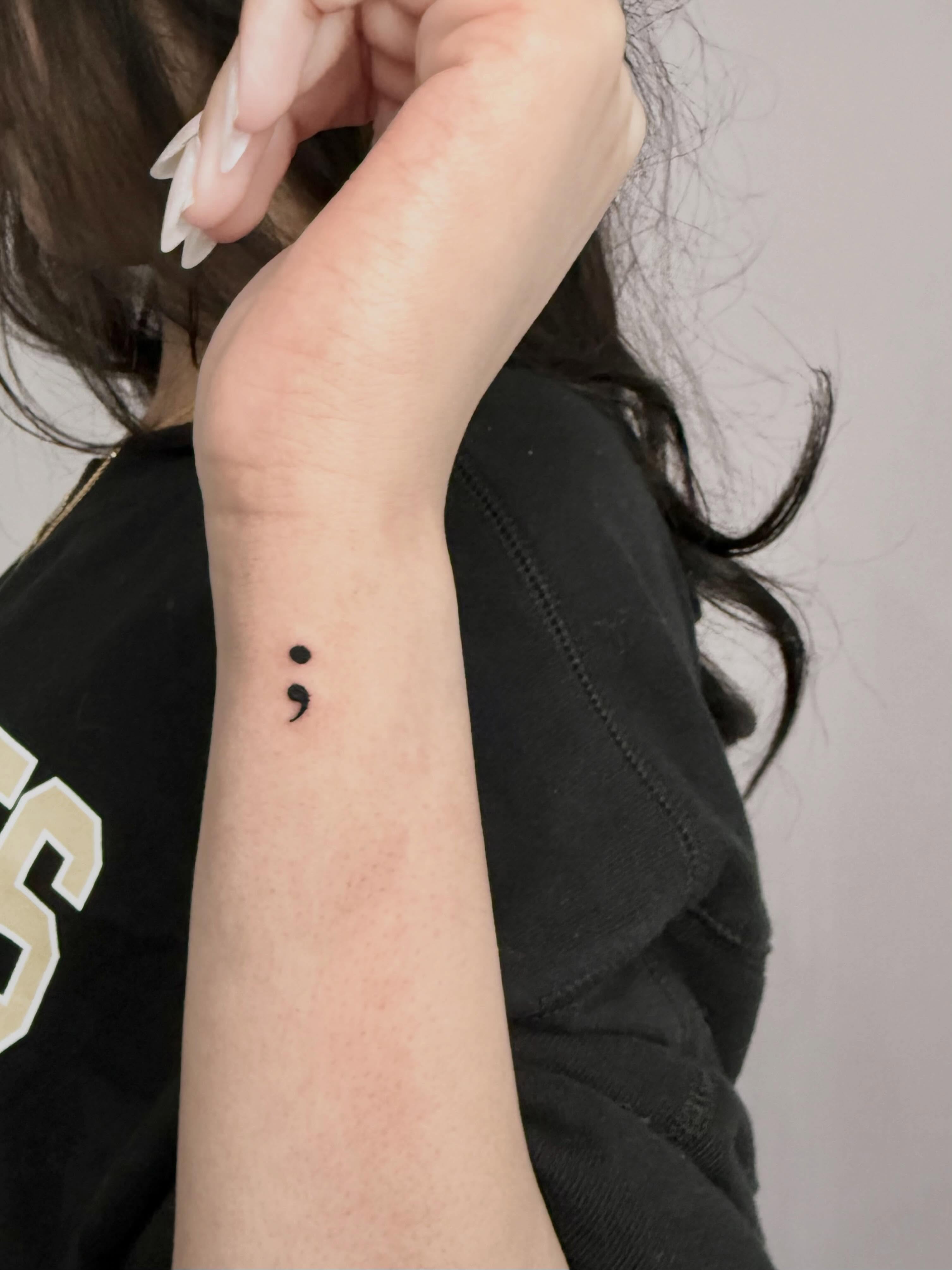 Semicolon minimalist tattoo on the forearm by Sierra Seton
