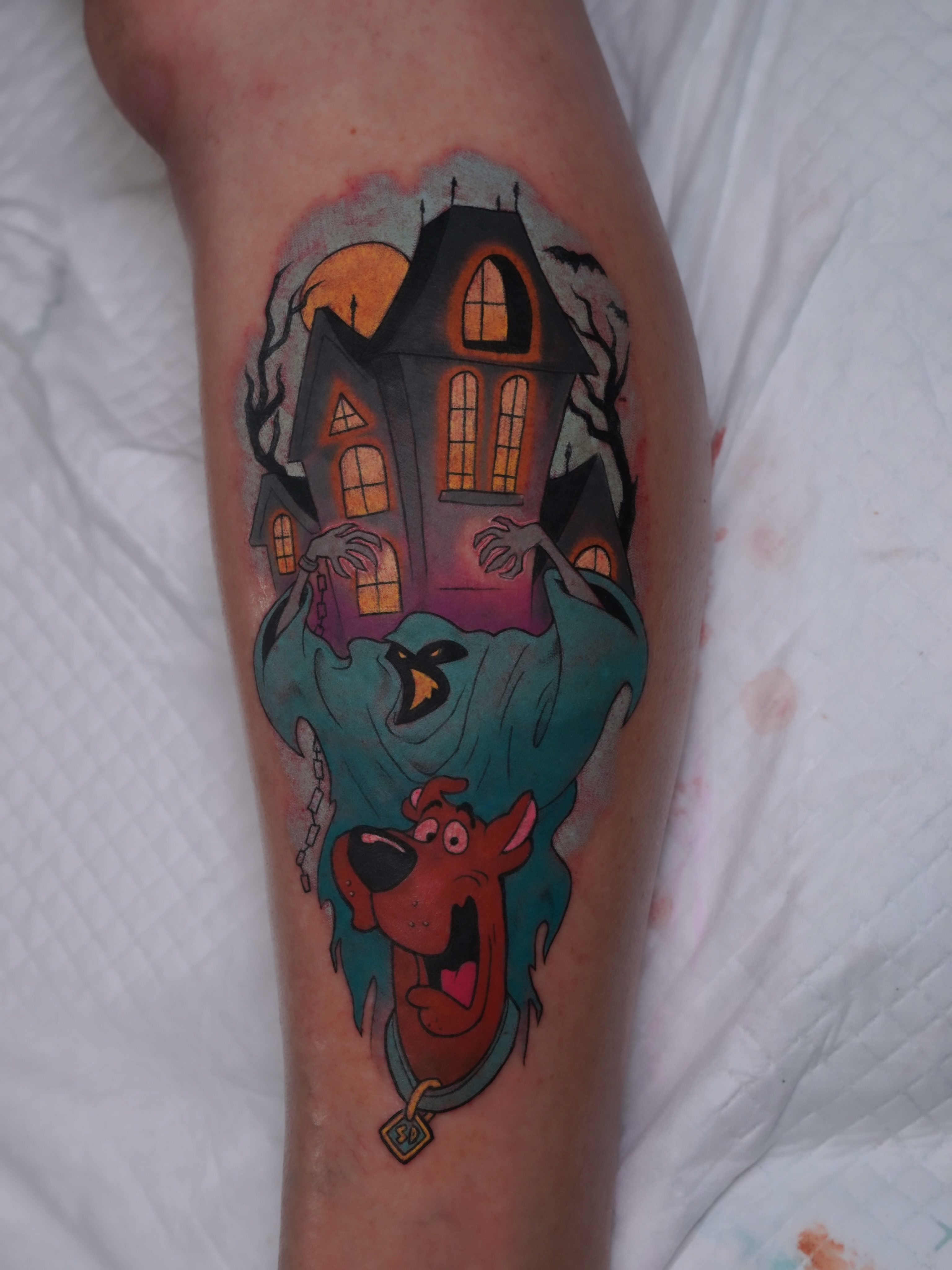Haunted house and scooby-doo new school tattoo on the forearm by Derek Foferek, Charlotte, North Carolina
