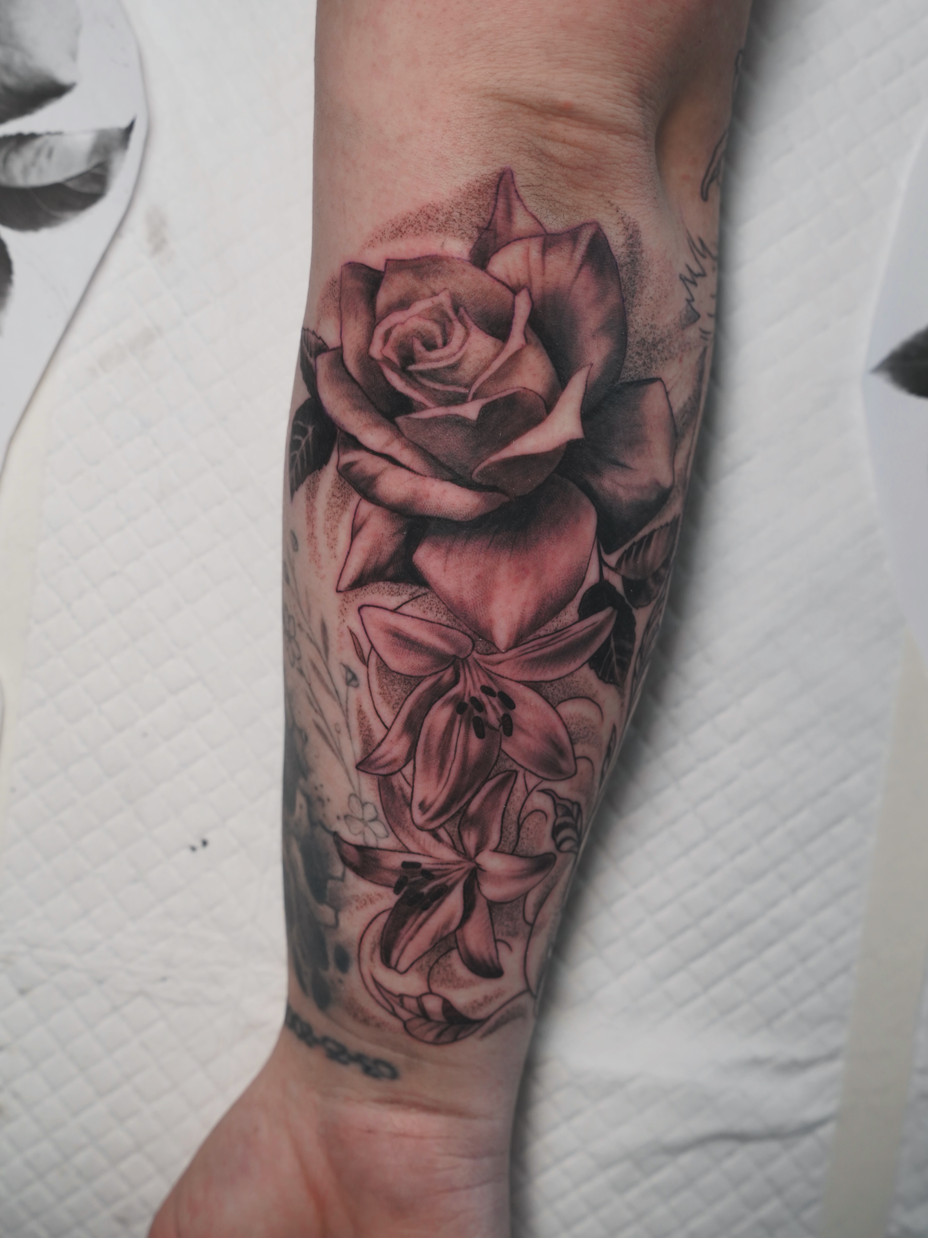 Rose and lily realism tattoo on the forearm by Derek Foferek, Charlotte, North Carolina