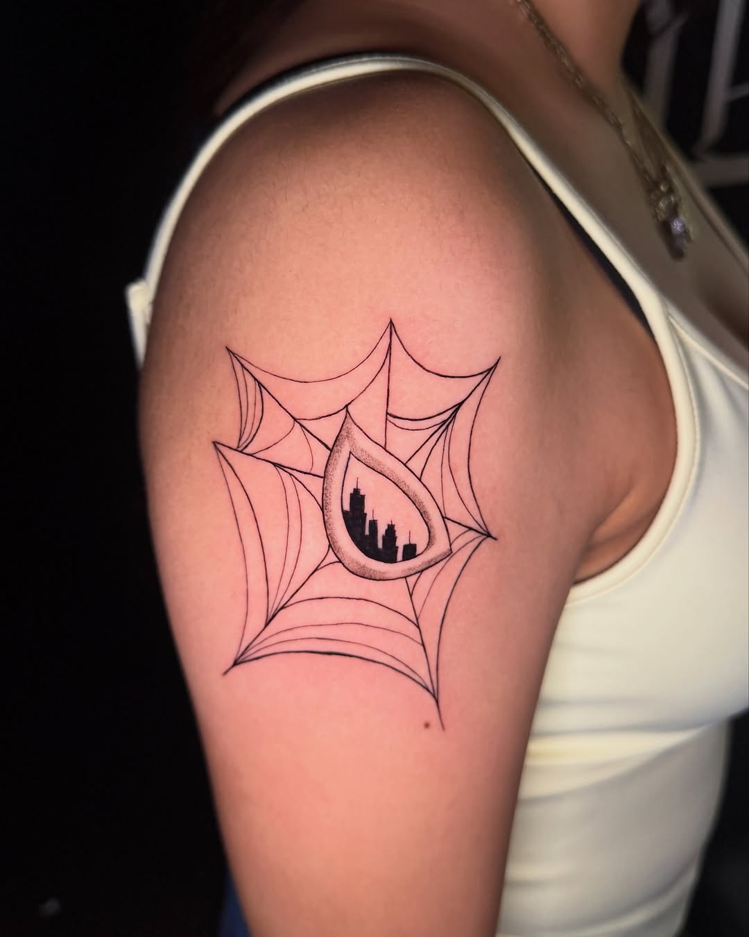 Spider web with city skyline blackwork tattoo on the shoulder by ๐๐ข๐ฃ๐ฑ ๐๐ฆ๐ฑ๐ฌ ๐๏ธ