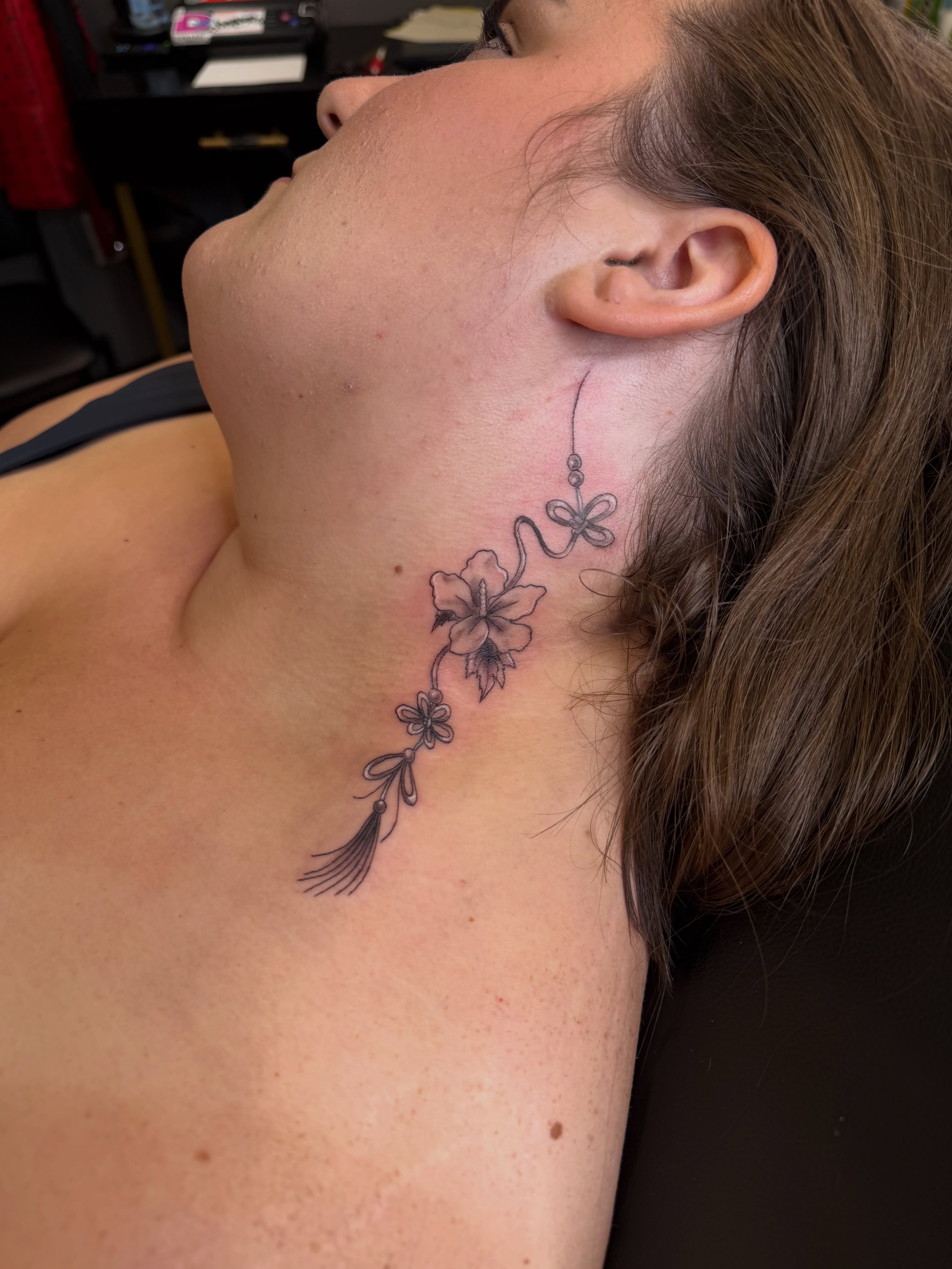 Floral arrangement black and grey tattoo on the neck by Rain David