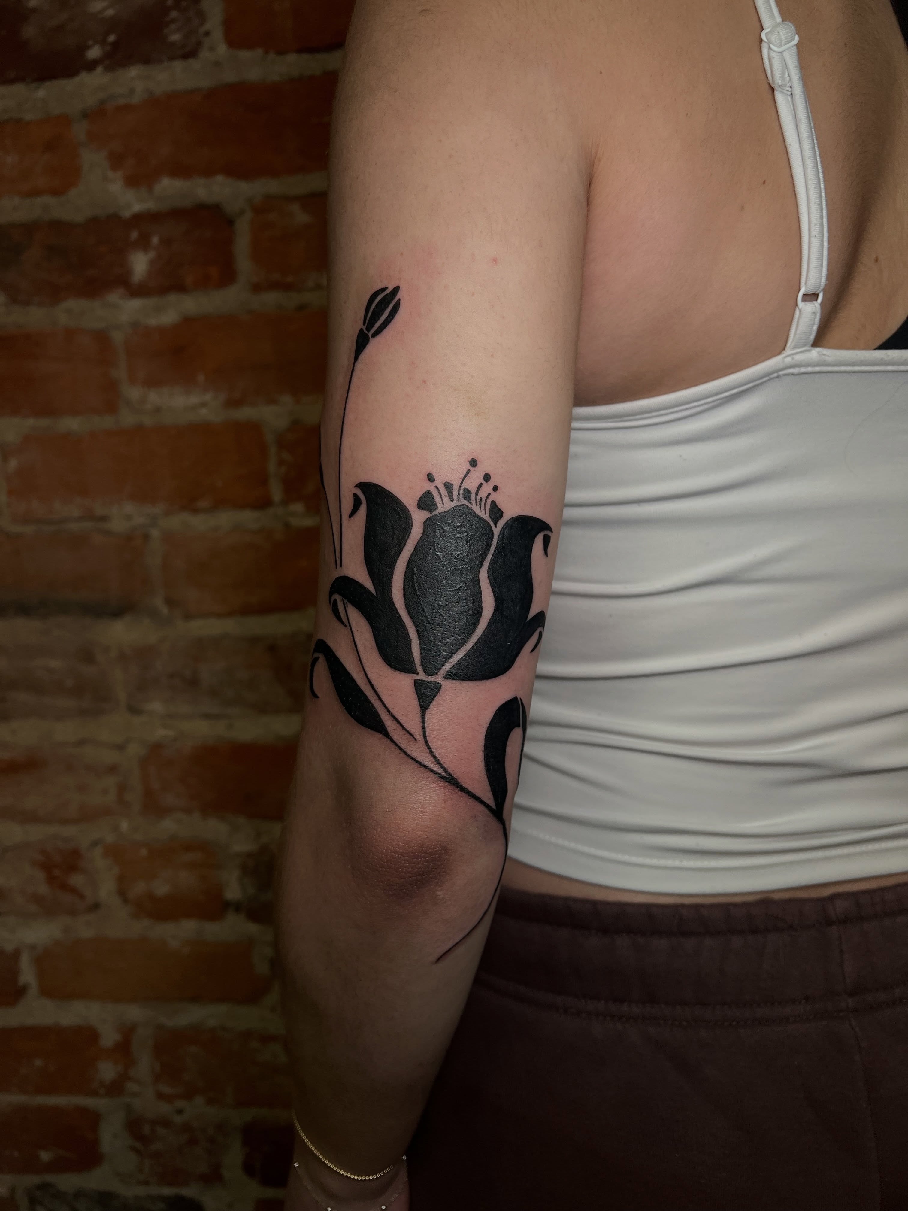 Flower black and grey tattoo on the forearm by Uncomfy Comfort Tattoos LLC