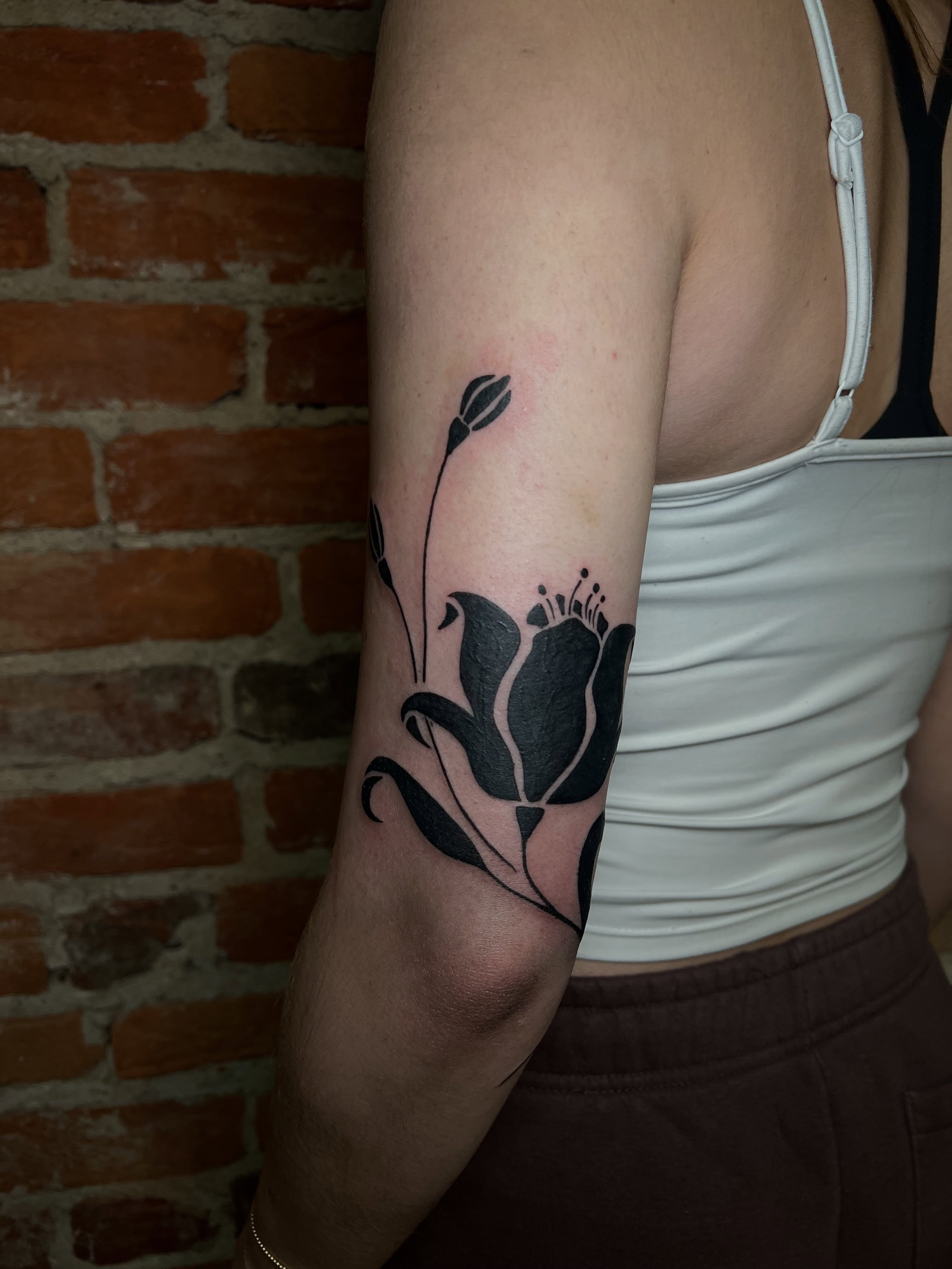 Flower black and grey tattoo on the forearm by Uncomfy Comfort Tattoos LLC