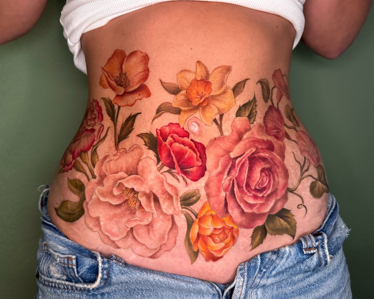 Floral bouquet realism tattoo on the torso by Nichole Lorence