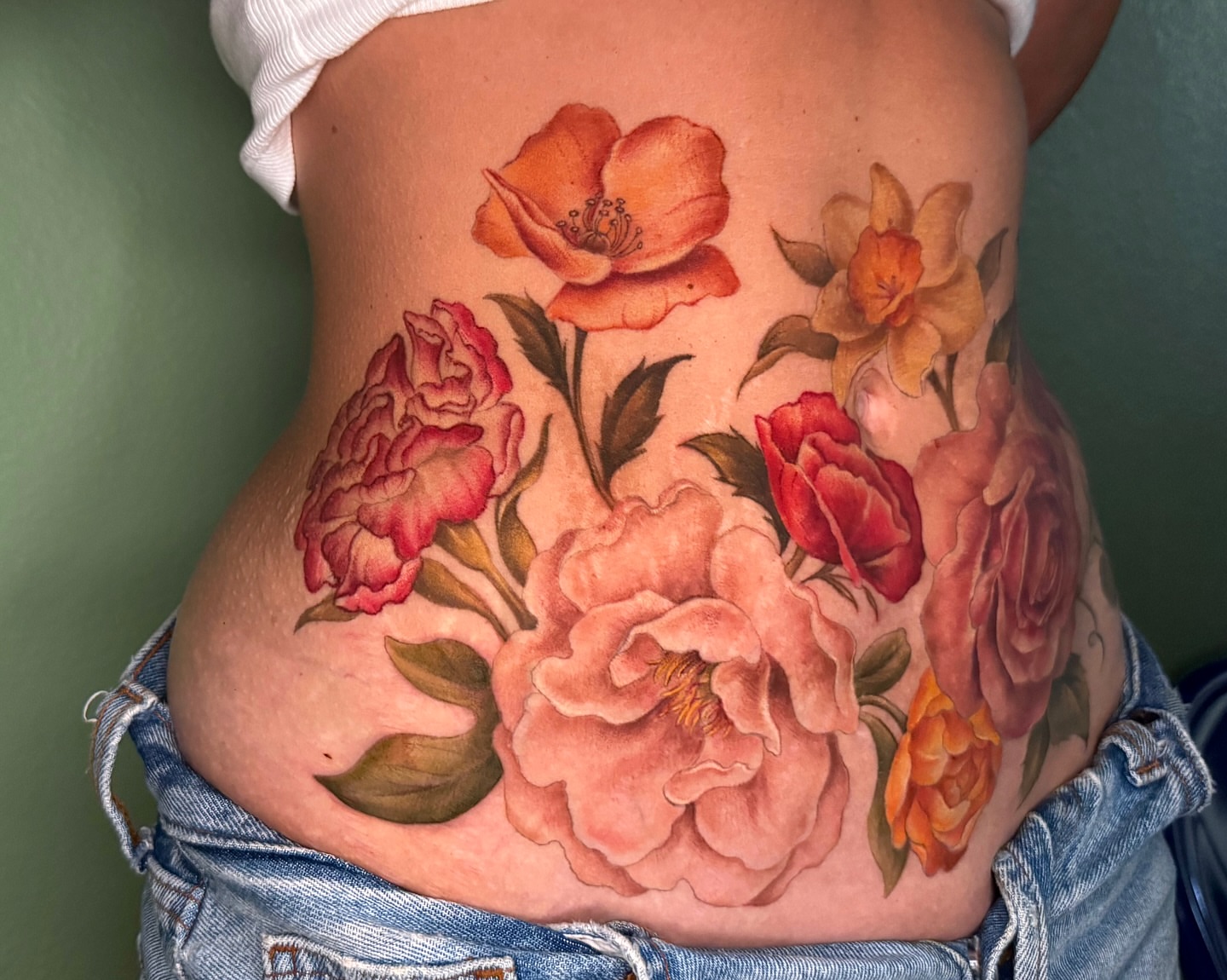 Floral bouquet realism tattoo on the torso by Nichole Lorence