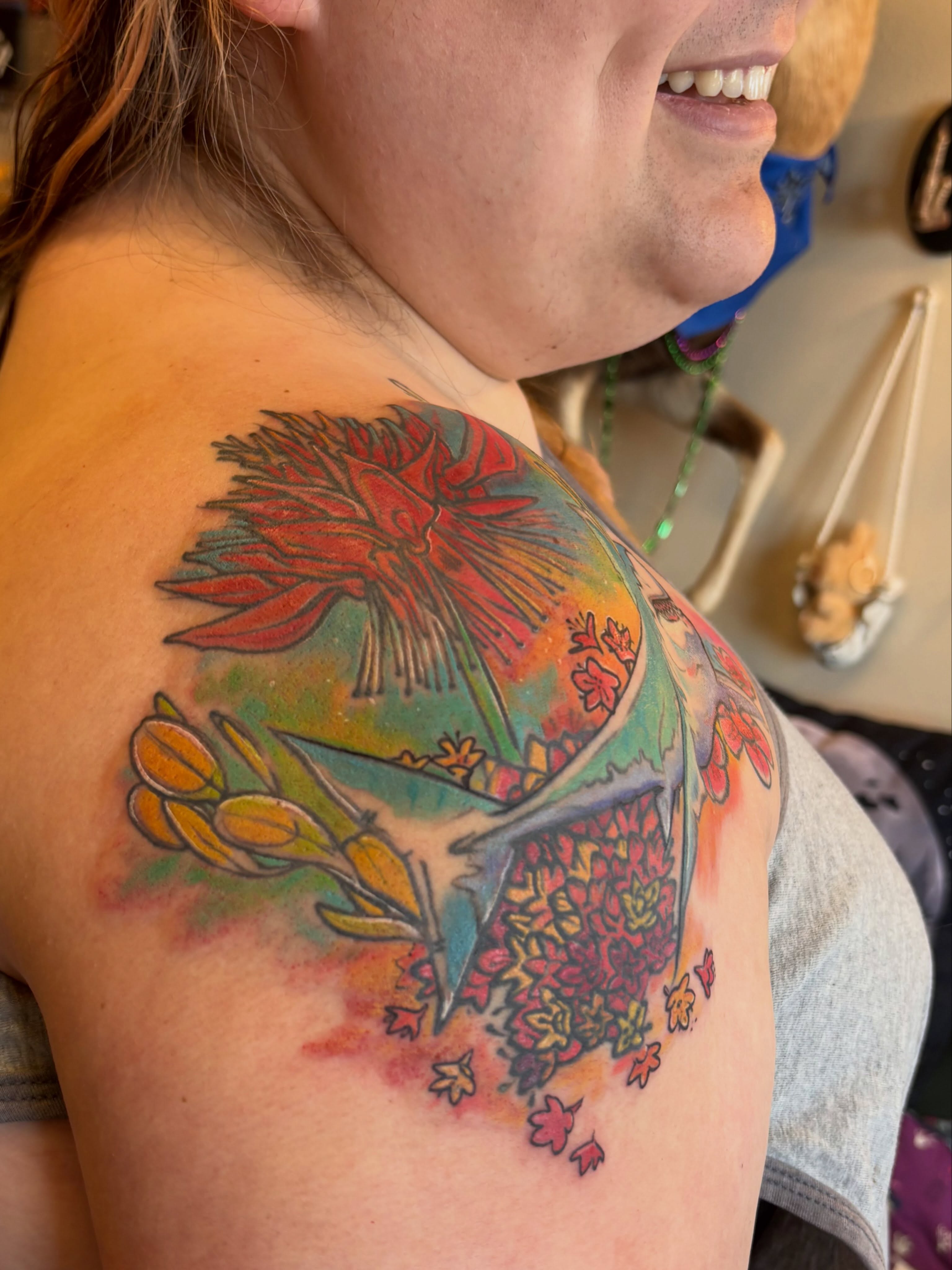 Flower bouquet watercolor tattoo on the shoulder by Zoe Brookes