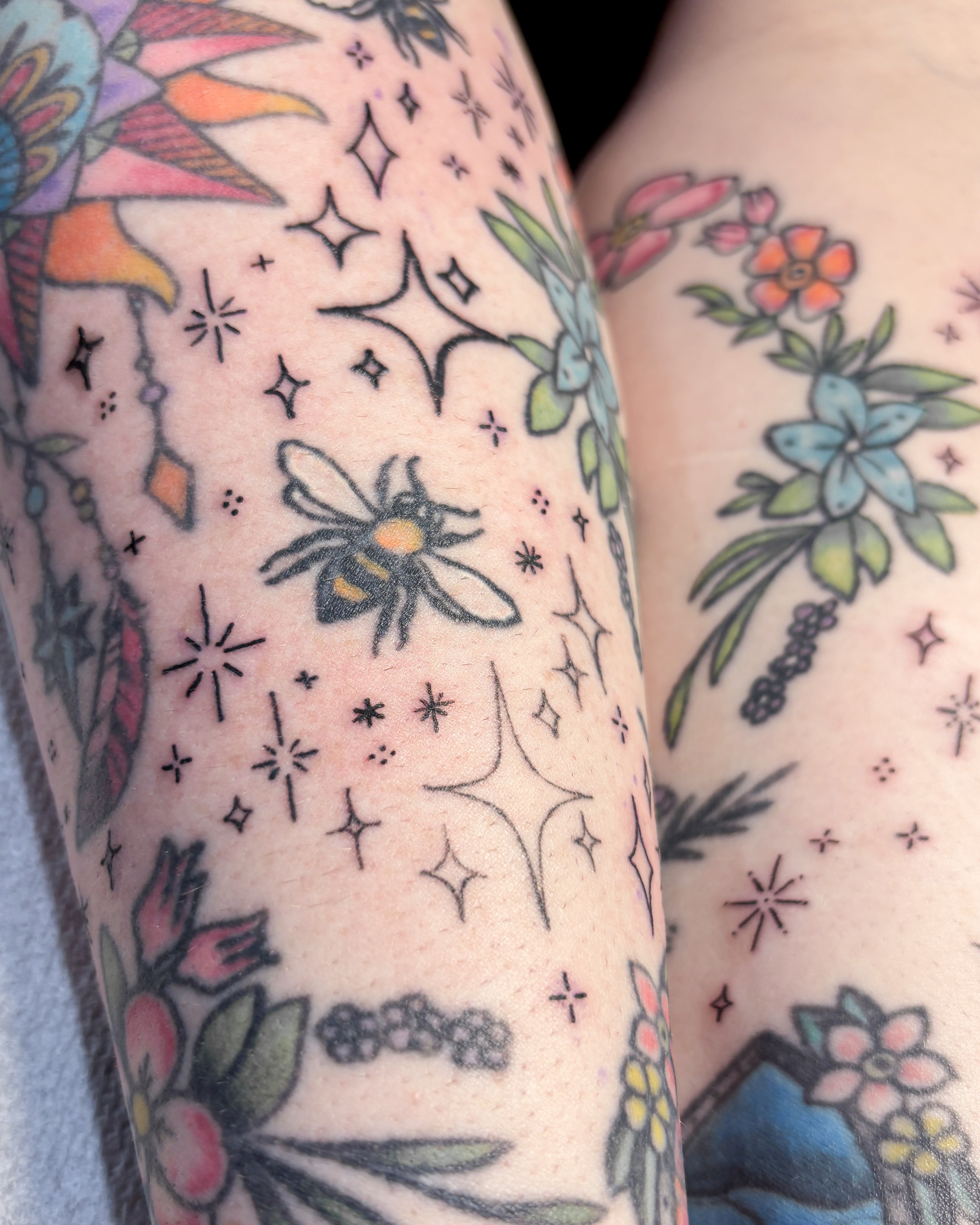 Bee and floral American traditional tattoo on the forearm by Liz Cook