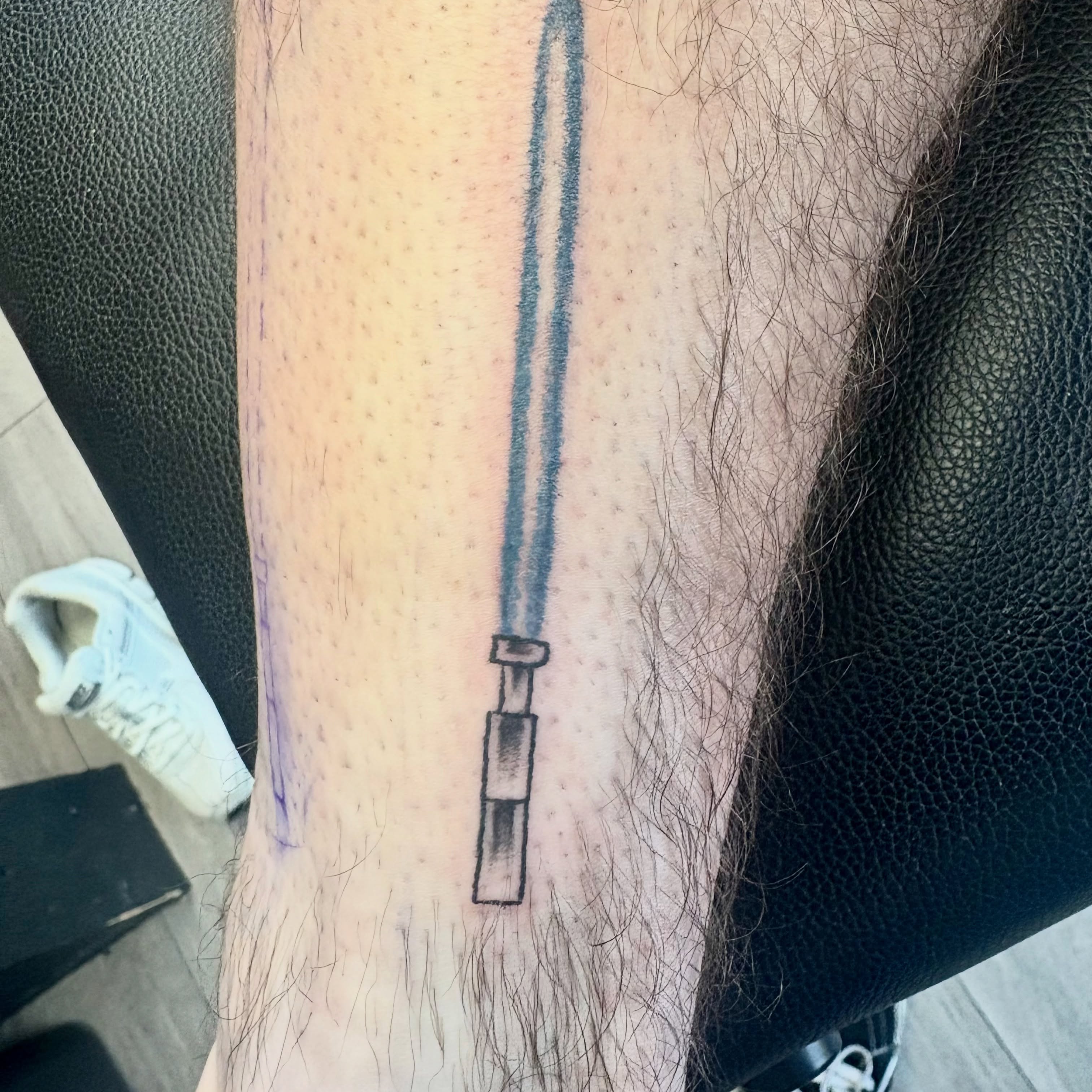 Lightsaber black and grey tattoo on the forearm by Landon Bagley