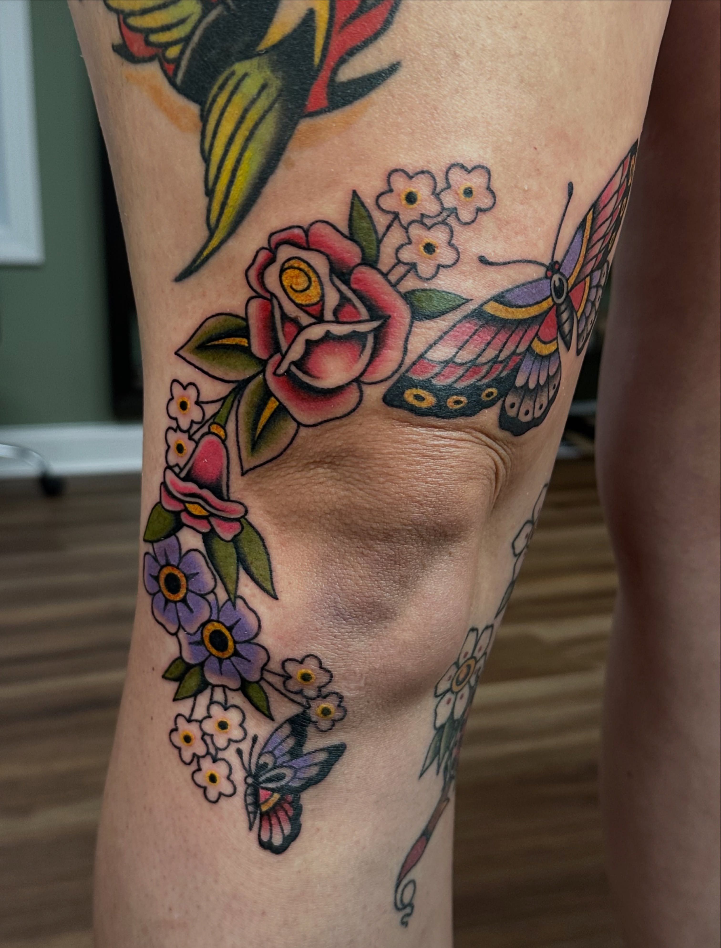 Butterfly and flowers American traditional tattoo on the leg by Emily Masa