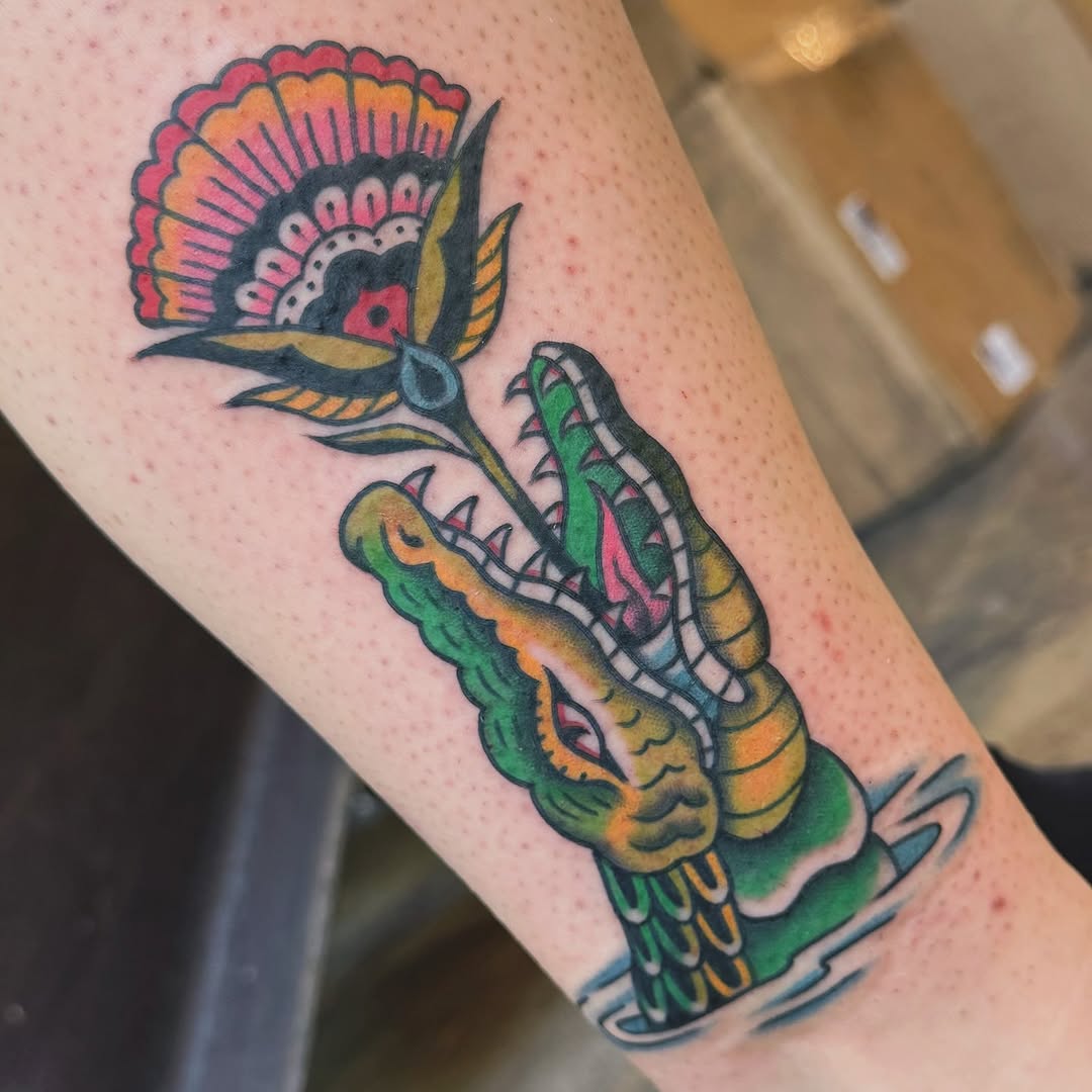 Alligator and flower American traditional tattoo on the forearm by Nikki Bee