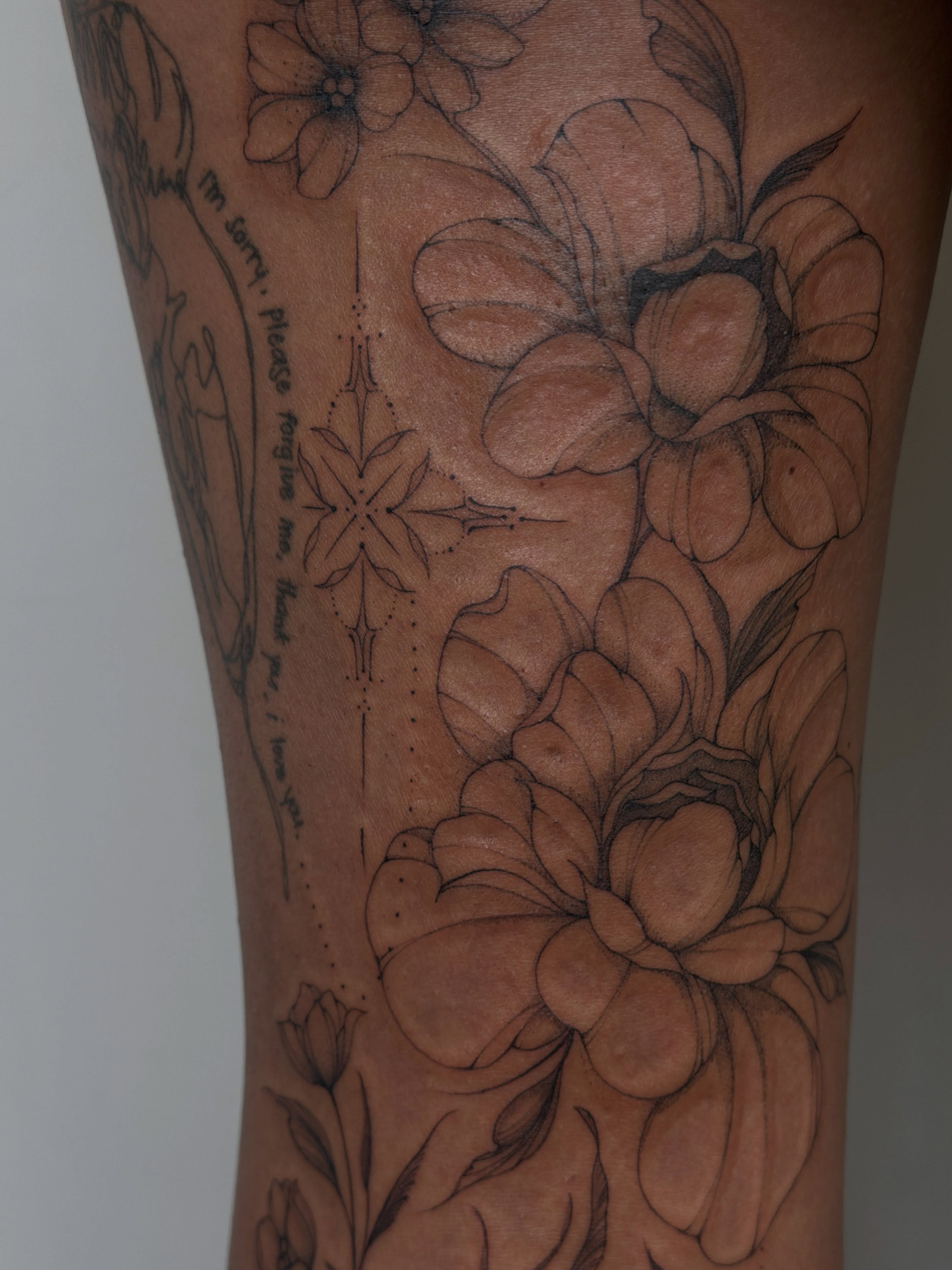 Floral arrangement black and grey tattoo on the forearm by Hannah Matthews