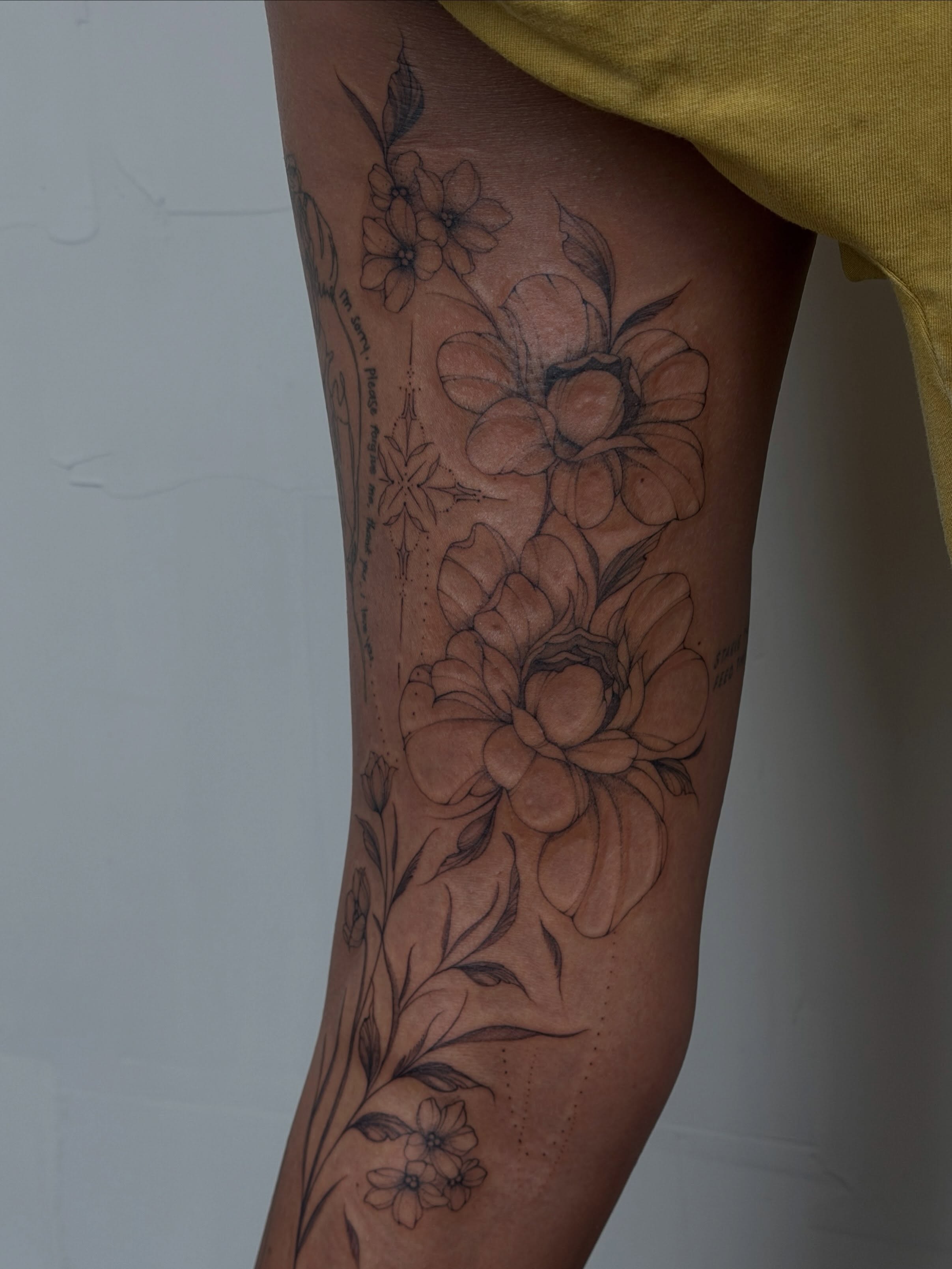 Floral arrangement realism tattoo on the thigh by Hannah Matthews