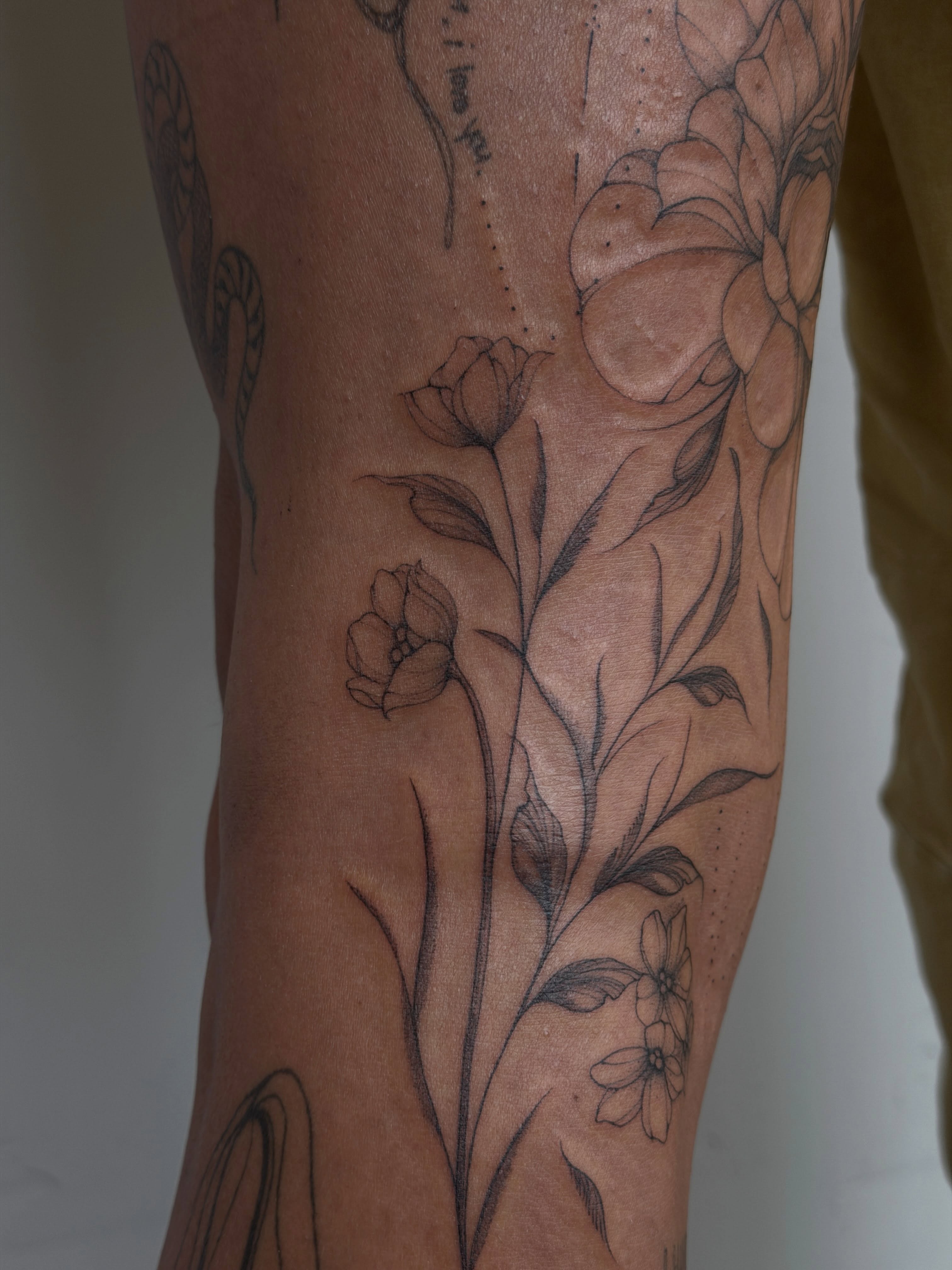Floral arrangement realism tattoo on the forearm by Hannah Matthews