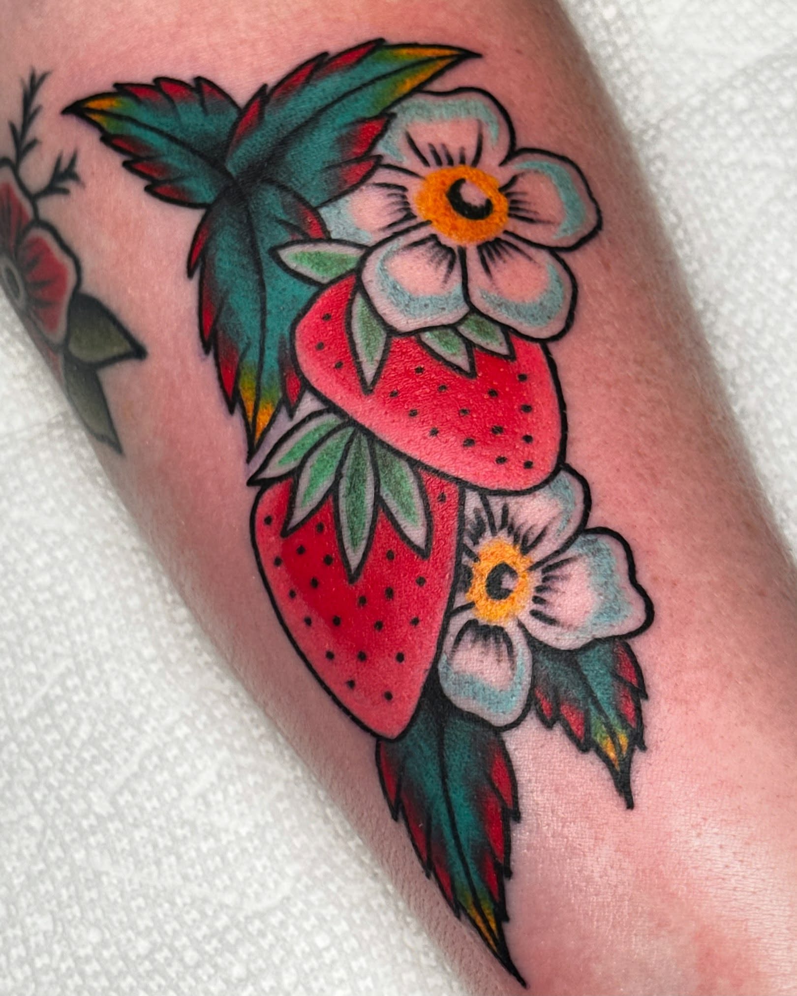 Strawberries and flowers American traditional tattoo on the forearm by Colbylee Tattoo Norwich