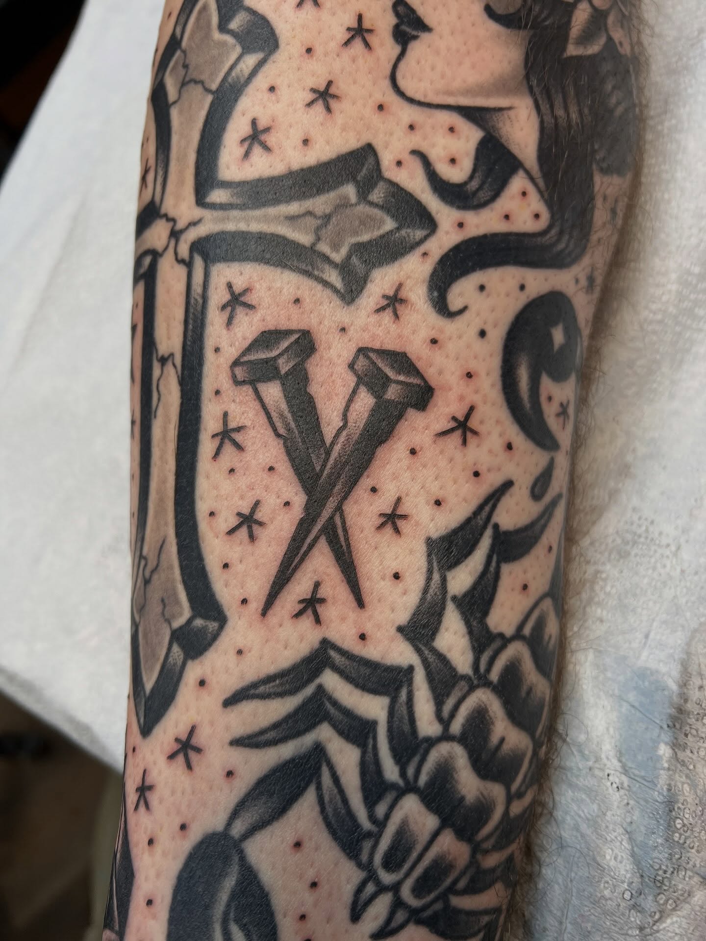 Nails and cross American traditional tattoo on the forearm by Tyler Van Pelt