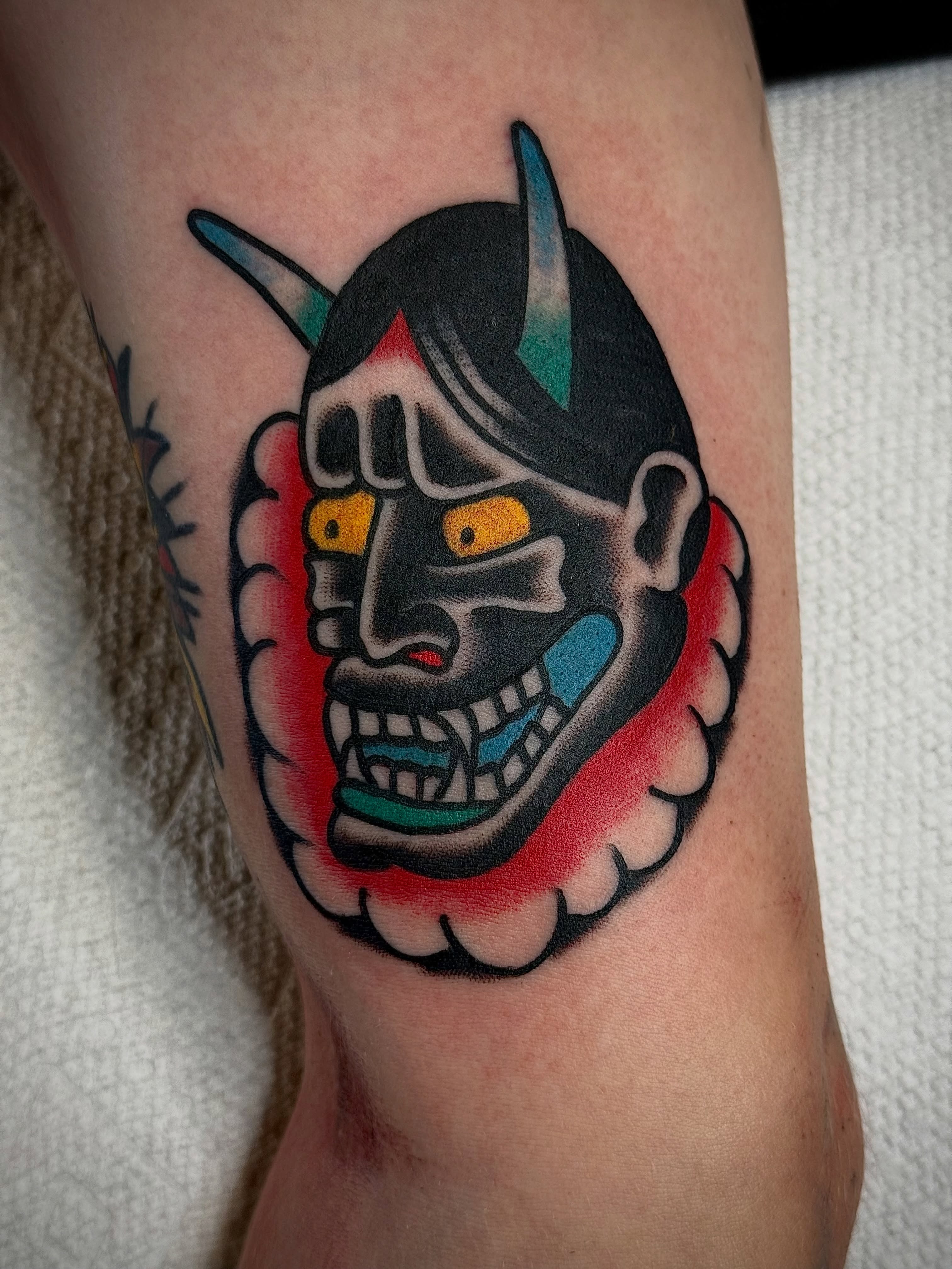 Japanese mask American traditional tattoo on the forearm by Chuck Derek Whitaker