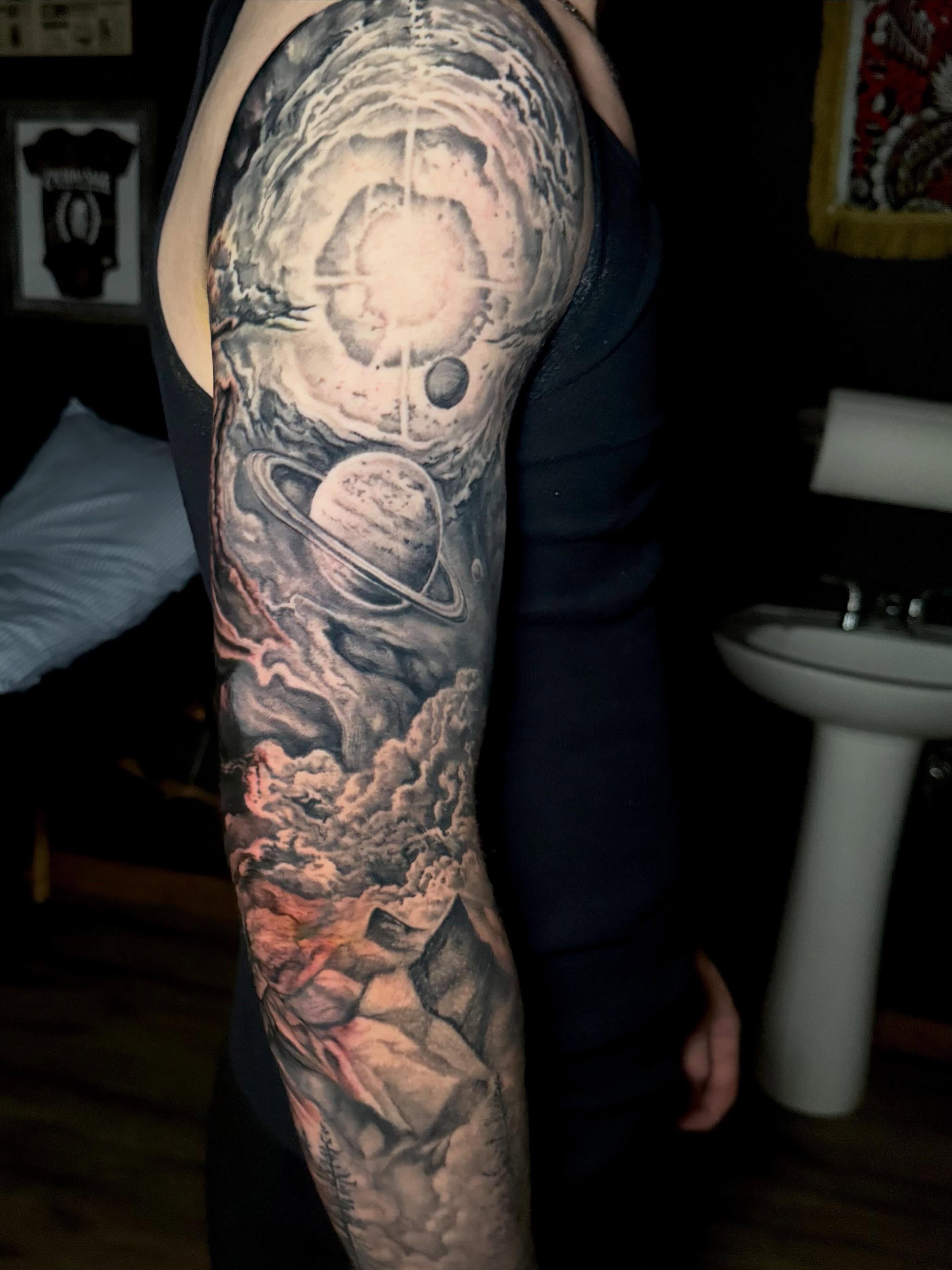 Space and celestial bodies realism tattoo on the forearm by Aaron Ysidro