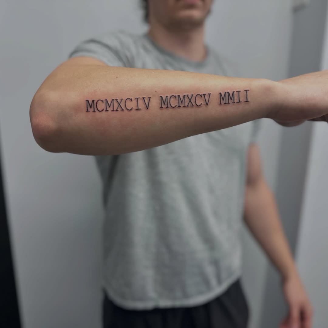 Roman numerals lettering script tattoo on the forearm by AJ
