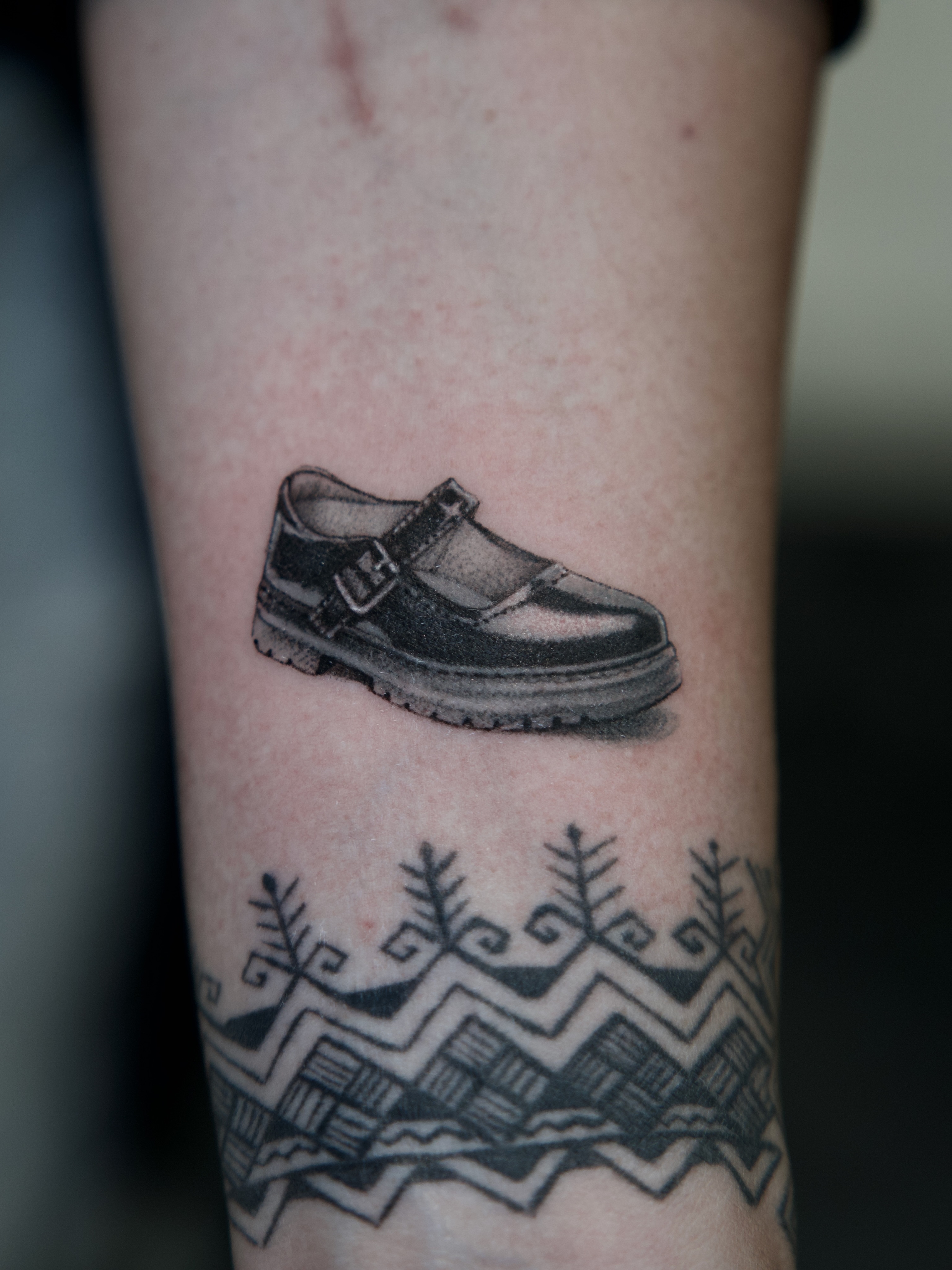 School shoe black and grey tattoo on the forearm by Raven Wood