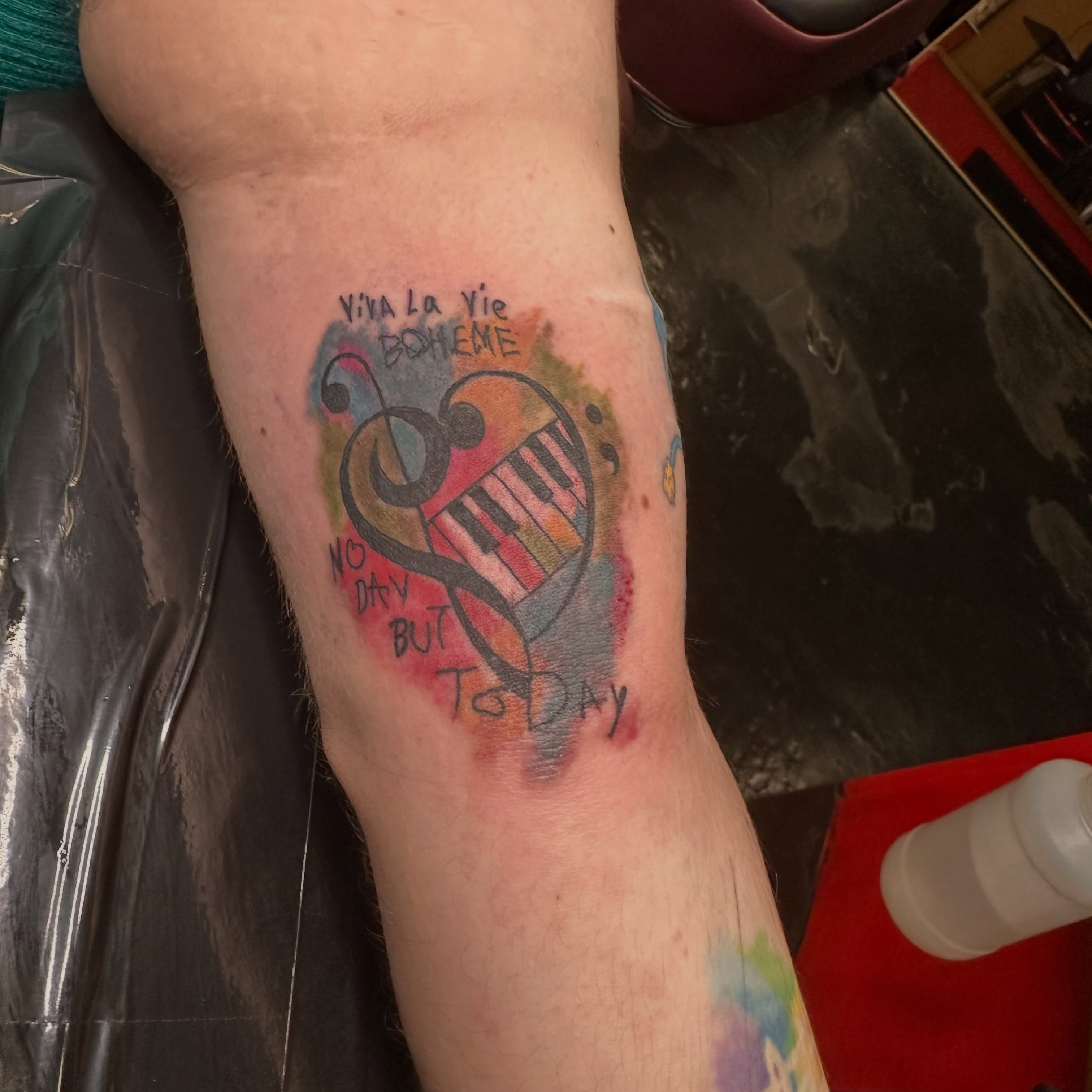 Music-themed design watercolor tattoo on the forearm by Red (Owner), Brooklyn, New York