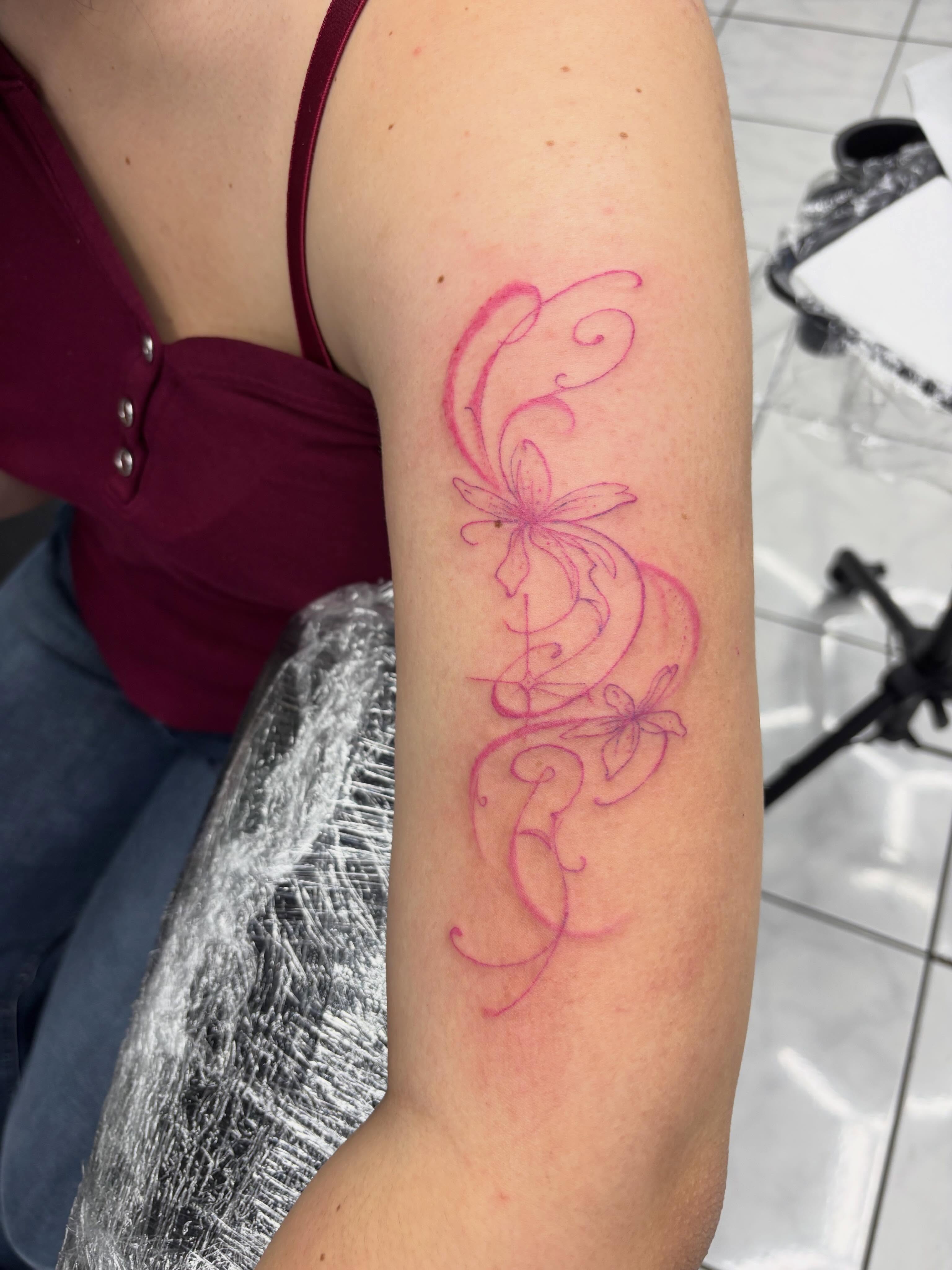 Floral design fine line tattoo on the forearm by Shadows Tattoos