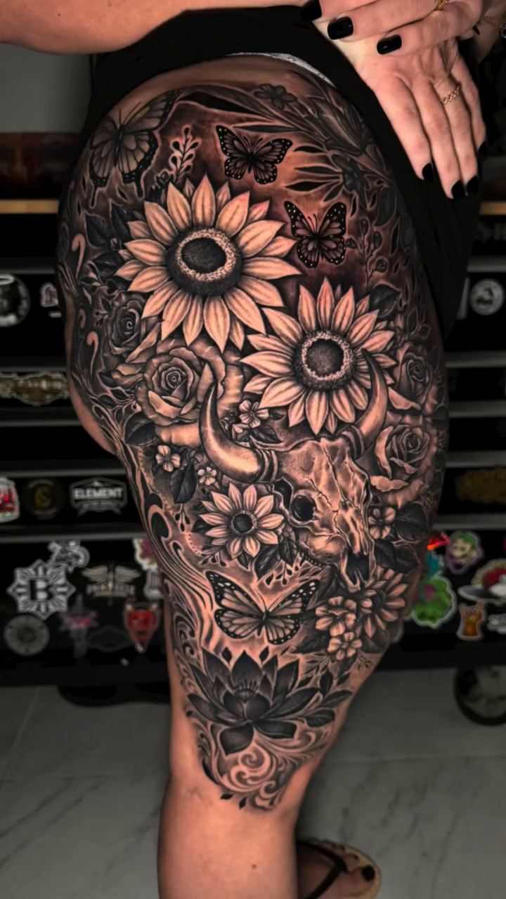 Floral arrangement with butterflies and skulls realism tattoo by professional tattoo artist