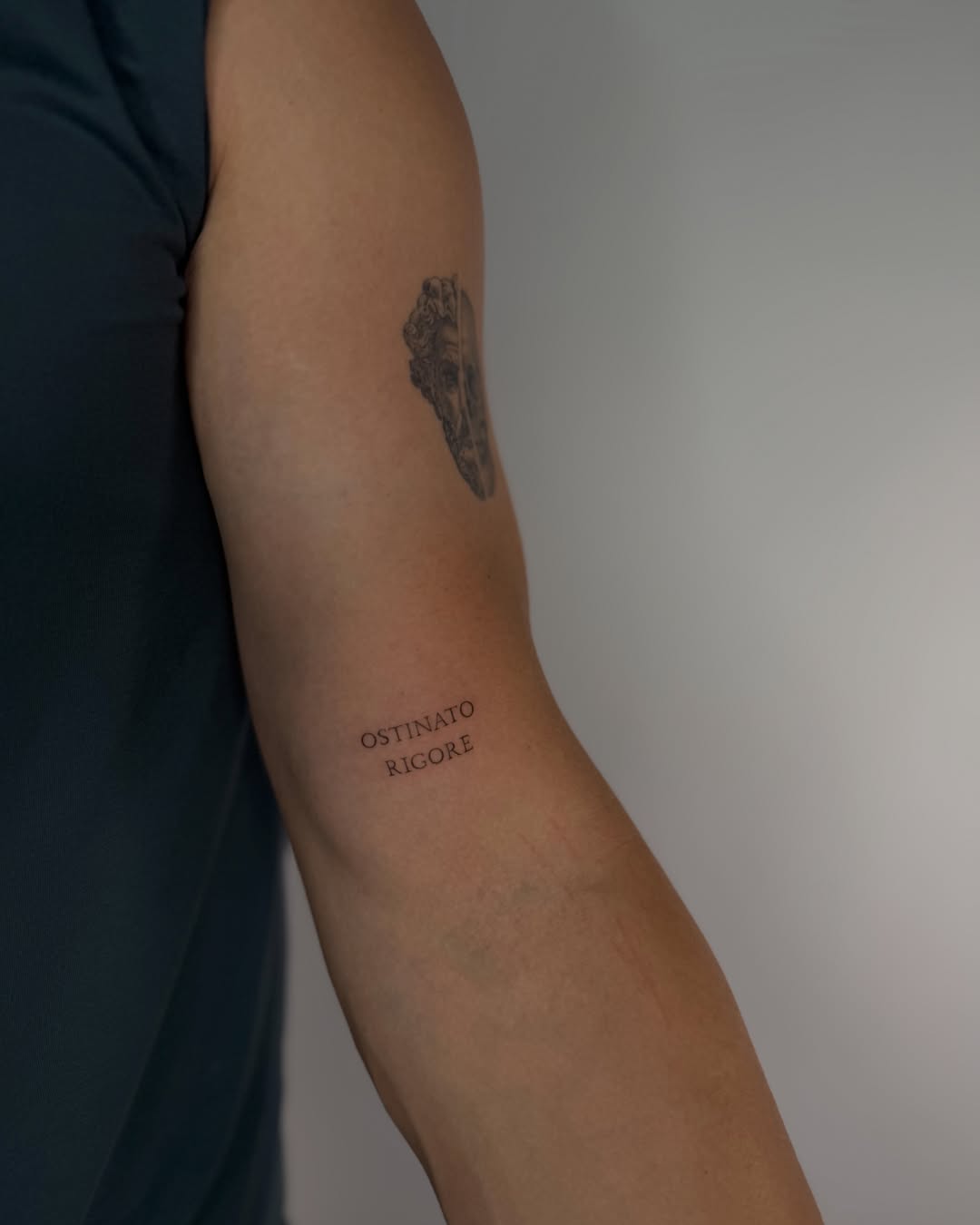 Mask black and grey tattoo on the forearm by Fineline Tattoos DFW