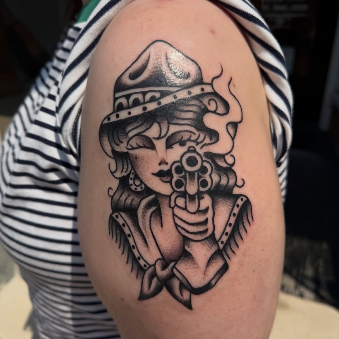 Flapper girl with gun American traditional tattoo on the shoulder by Hannah Jean