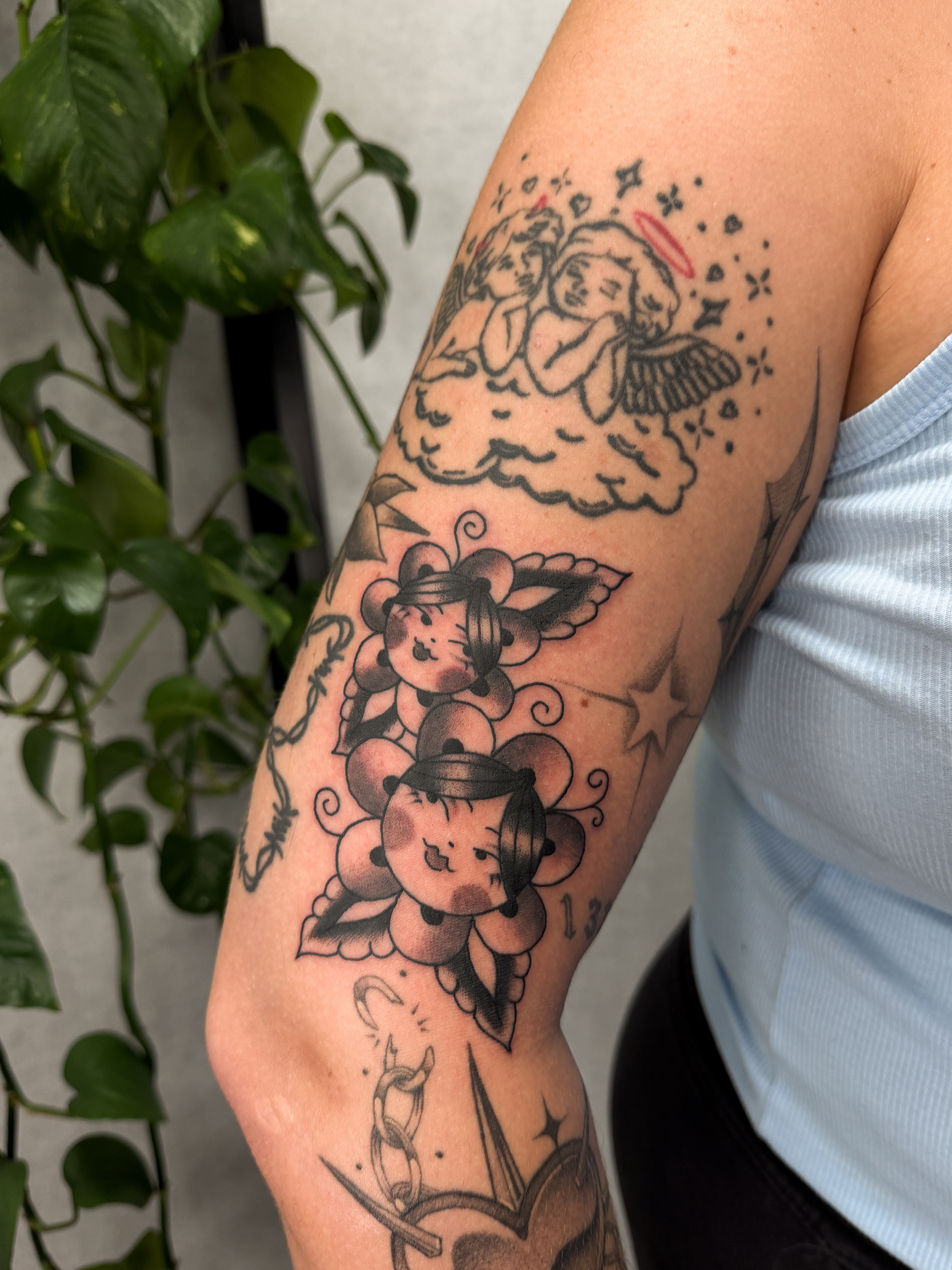 Angels and cherubs American traditional tattoo on the forearm by Hannah Eddy