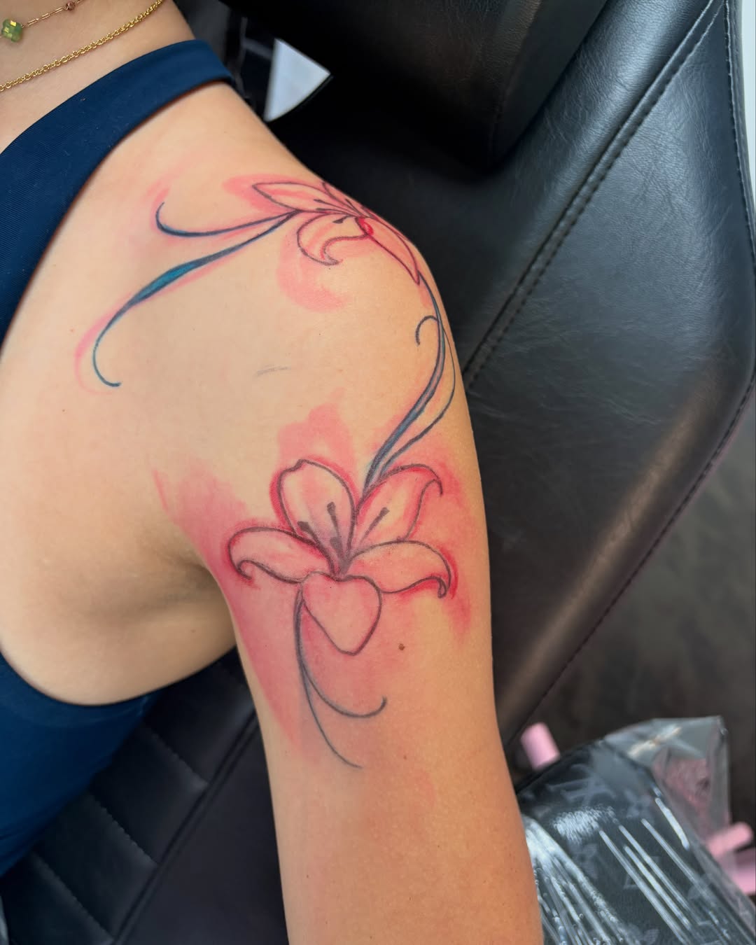 Lily watercolor tattoo on the shoulder by Avery Mullins