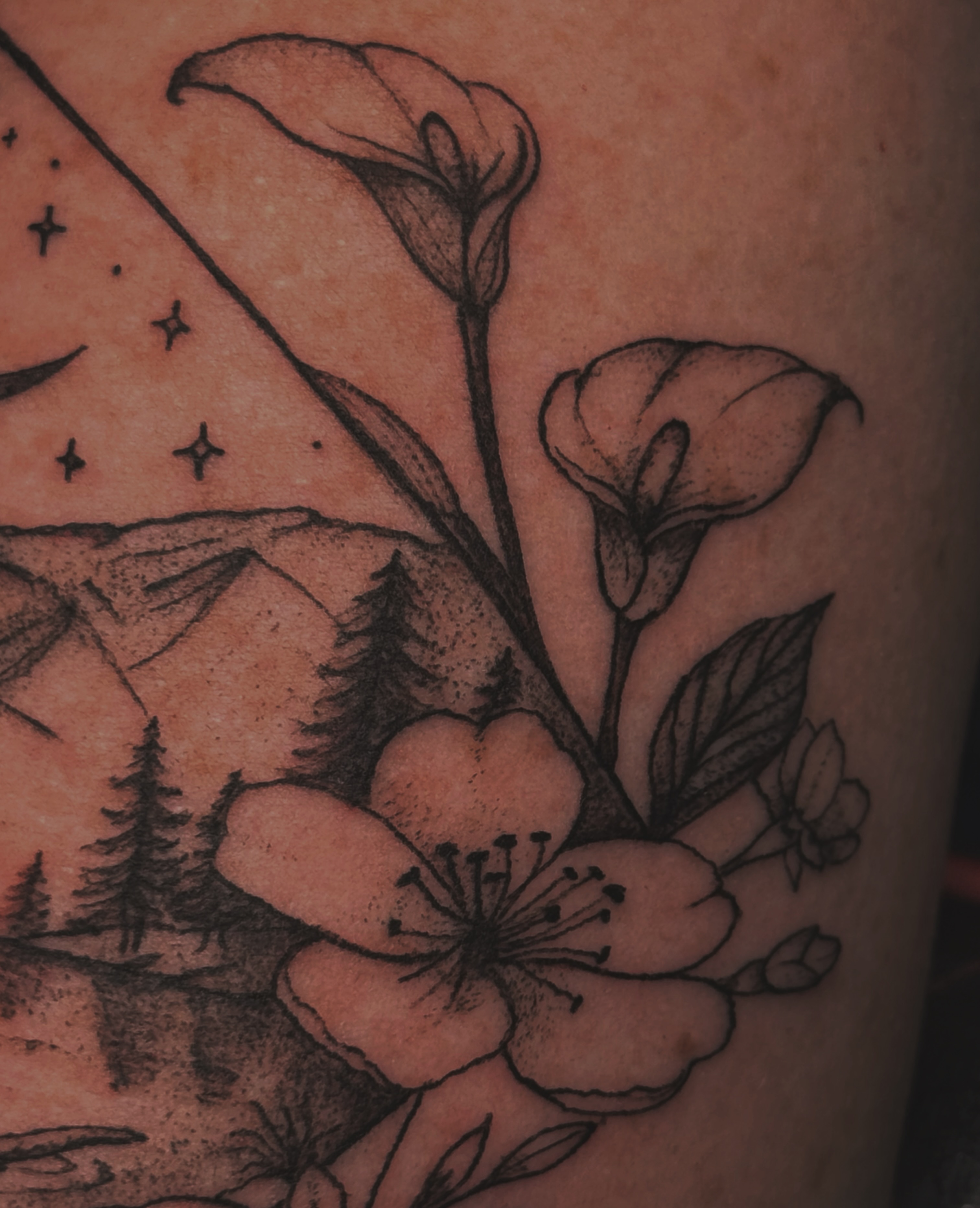 Mountain landscape with flowers black and grey tattoo on the upper arm by Kaylee Castleton, Tooele, Utah