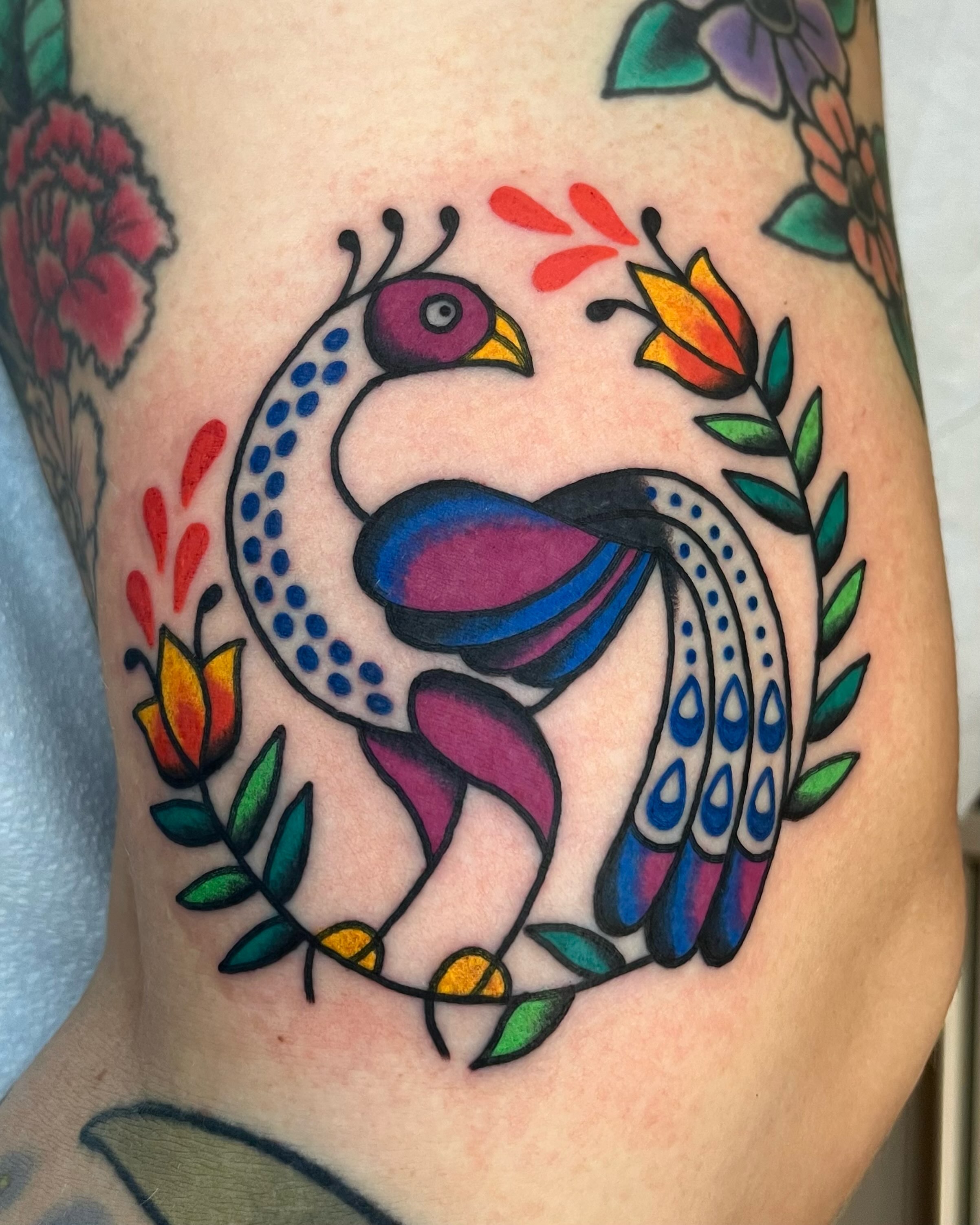 Peacock American traditional tattoo on the thigh by Em Adkins