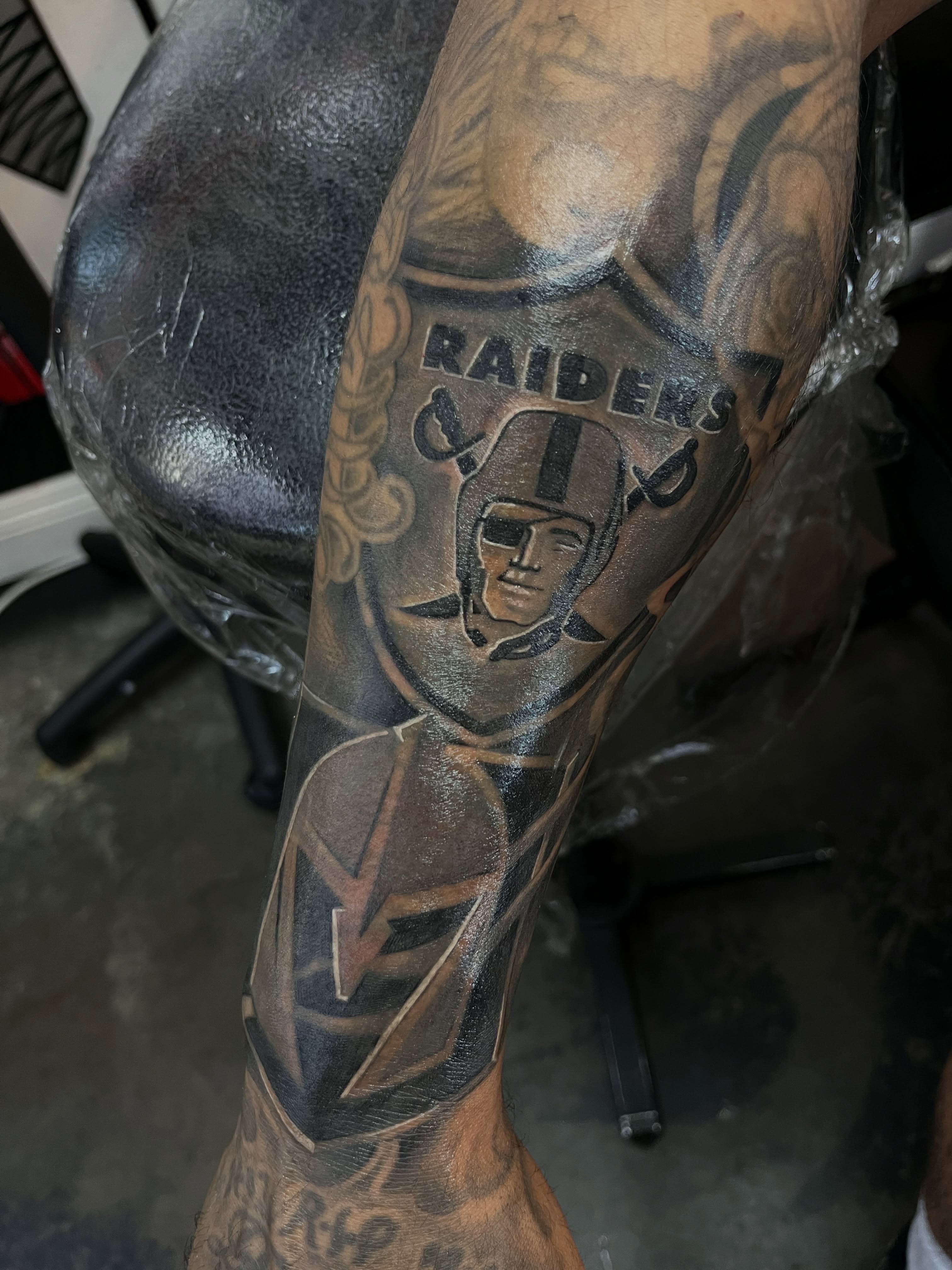 Raider helmet black and grey tattoo on the forearm by Kwete Tatuajes