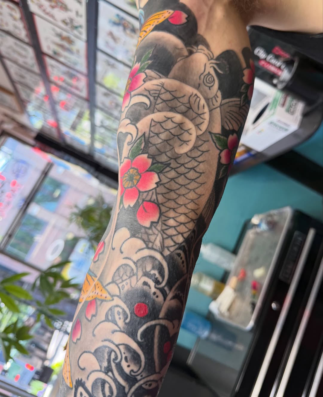 Koi fish and flowers American traditional tattoo on the forearm by DemianThompson