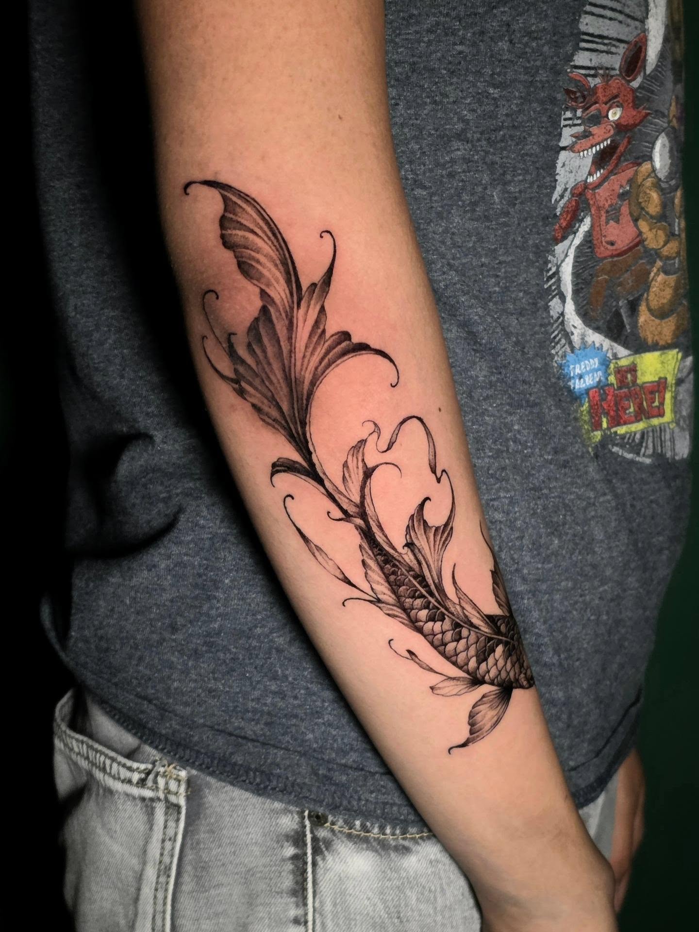 Feather black and grey tattoo on the forearm by Nick de Hoyos