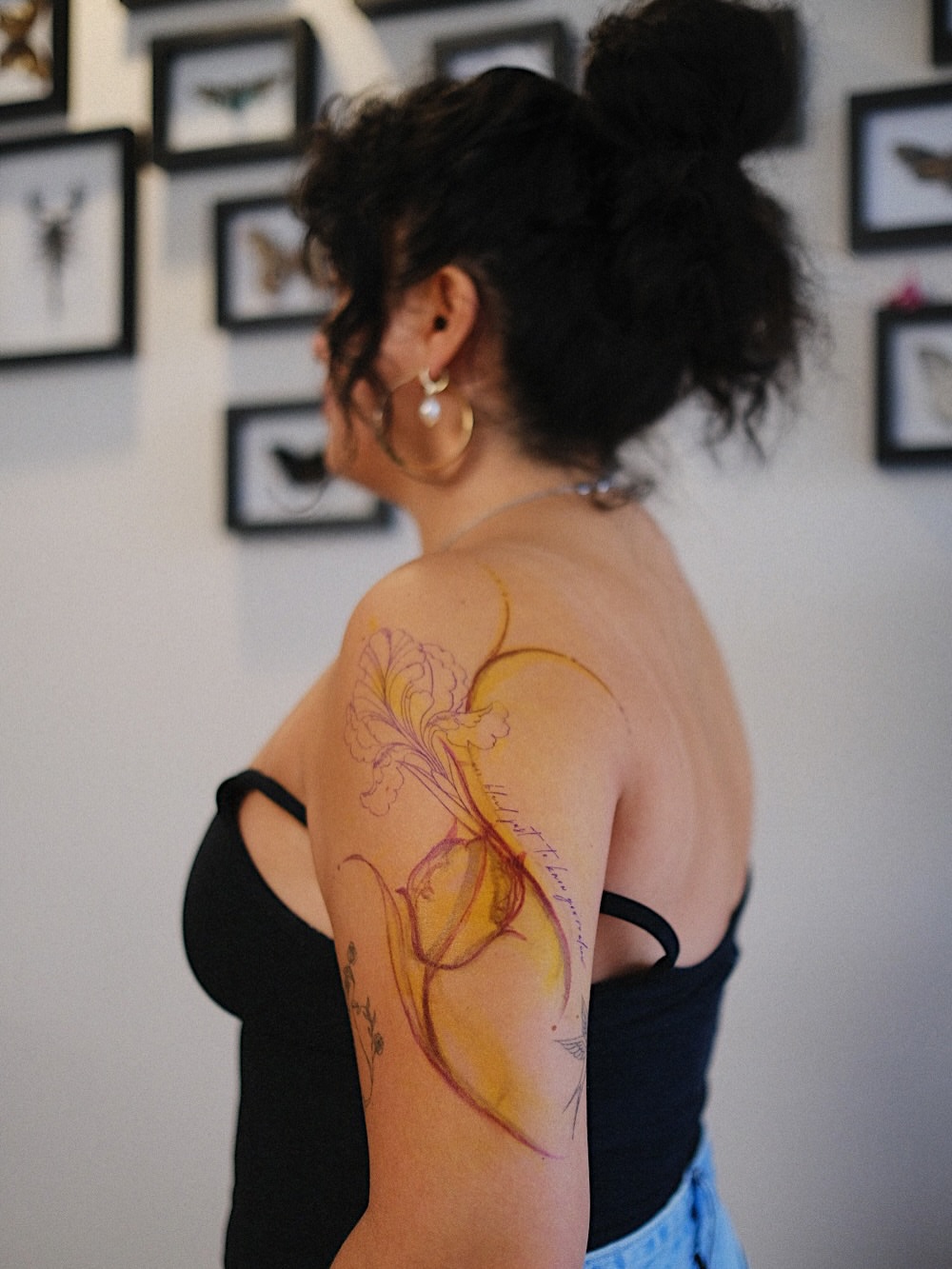Floral watercolor tattoo on the upper arm by Temple Adorned Tattoo