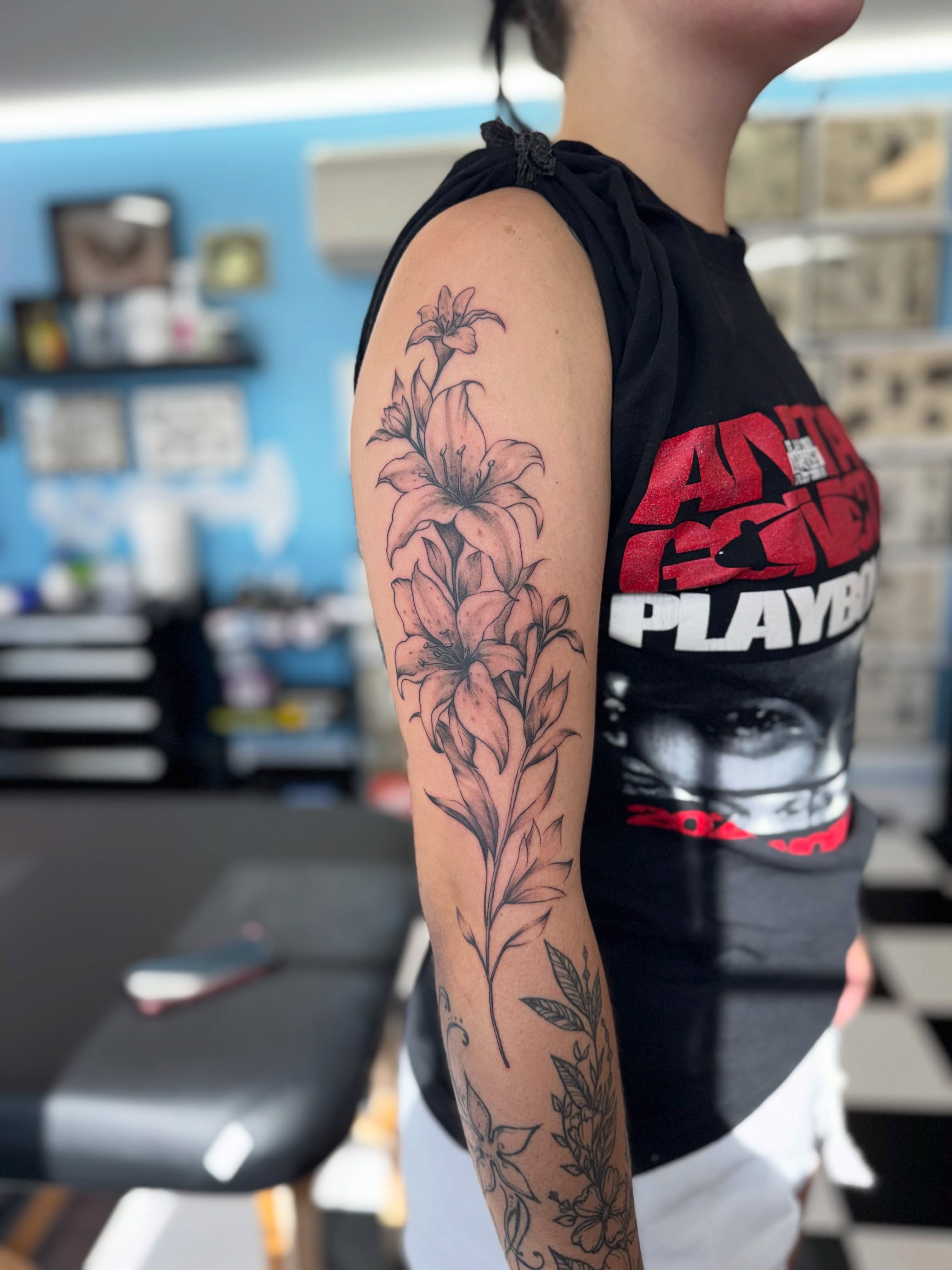 Lily flowers black and grey tattoo on the forearm by Béle Benard