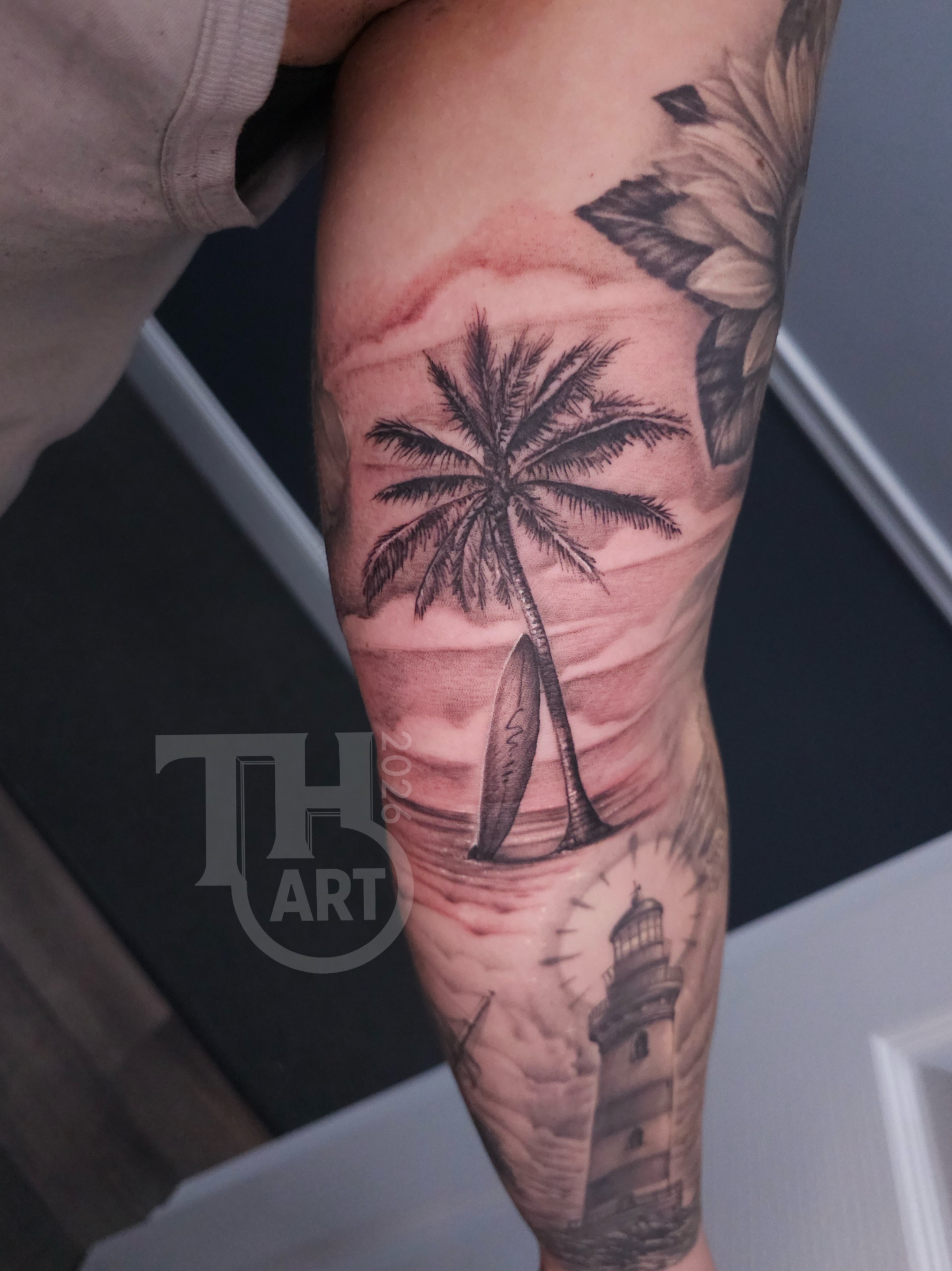 Palm tree and lighthouse realism tattoo on the forearm by Thomas Harris