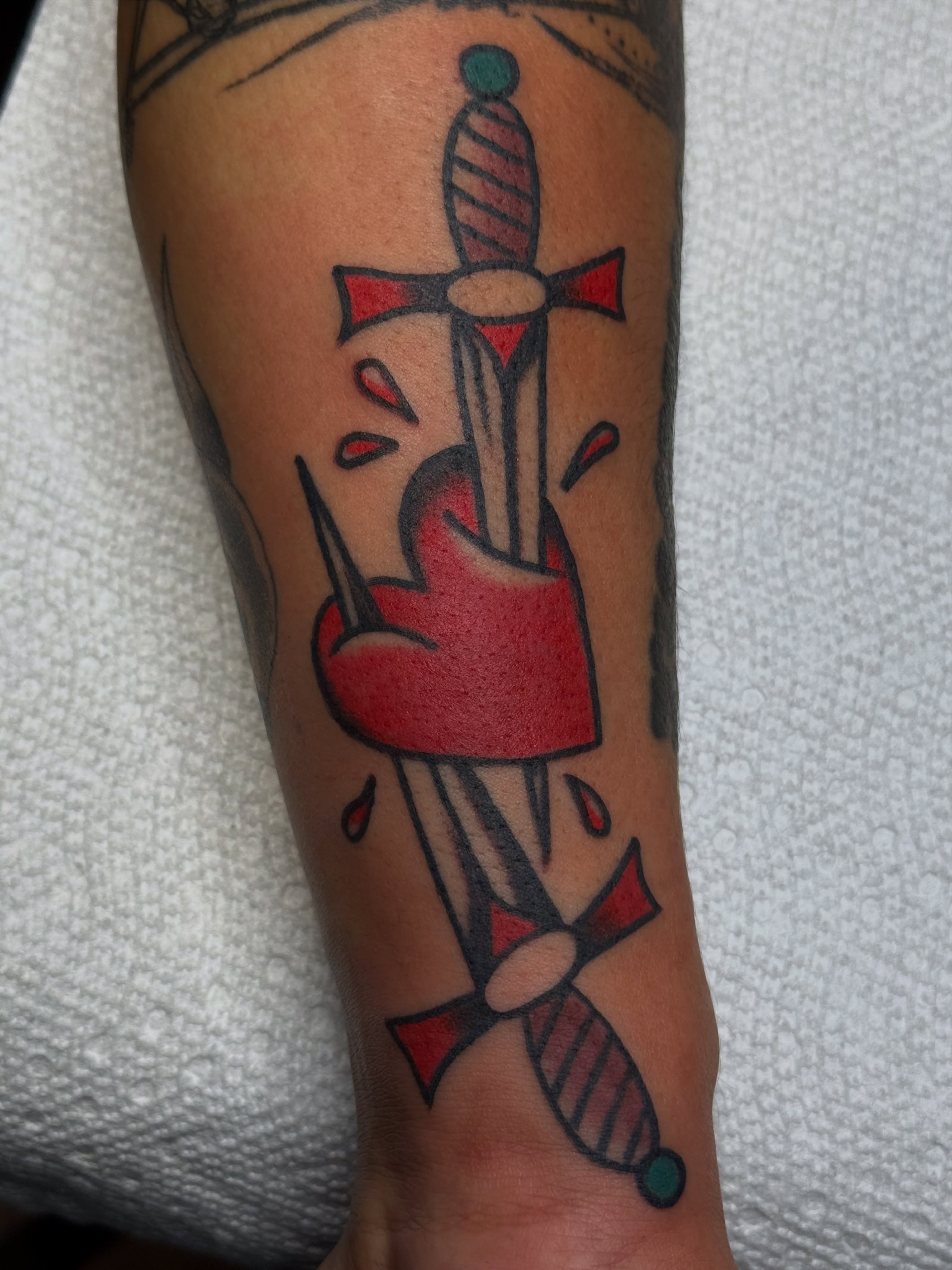 Sword and heart American traditional tattoo on the forearm by Clayton - TRADITIONAL TATTOOS